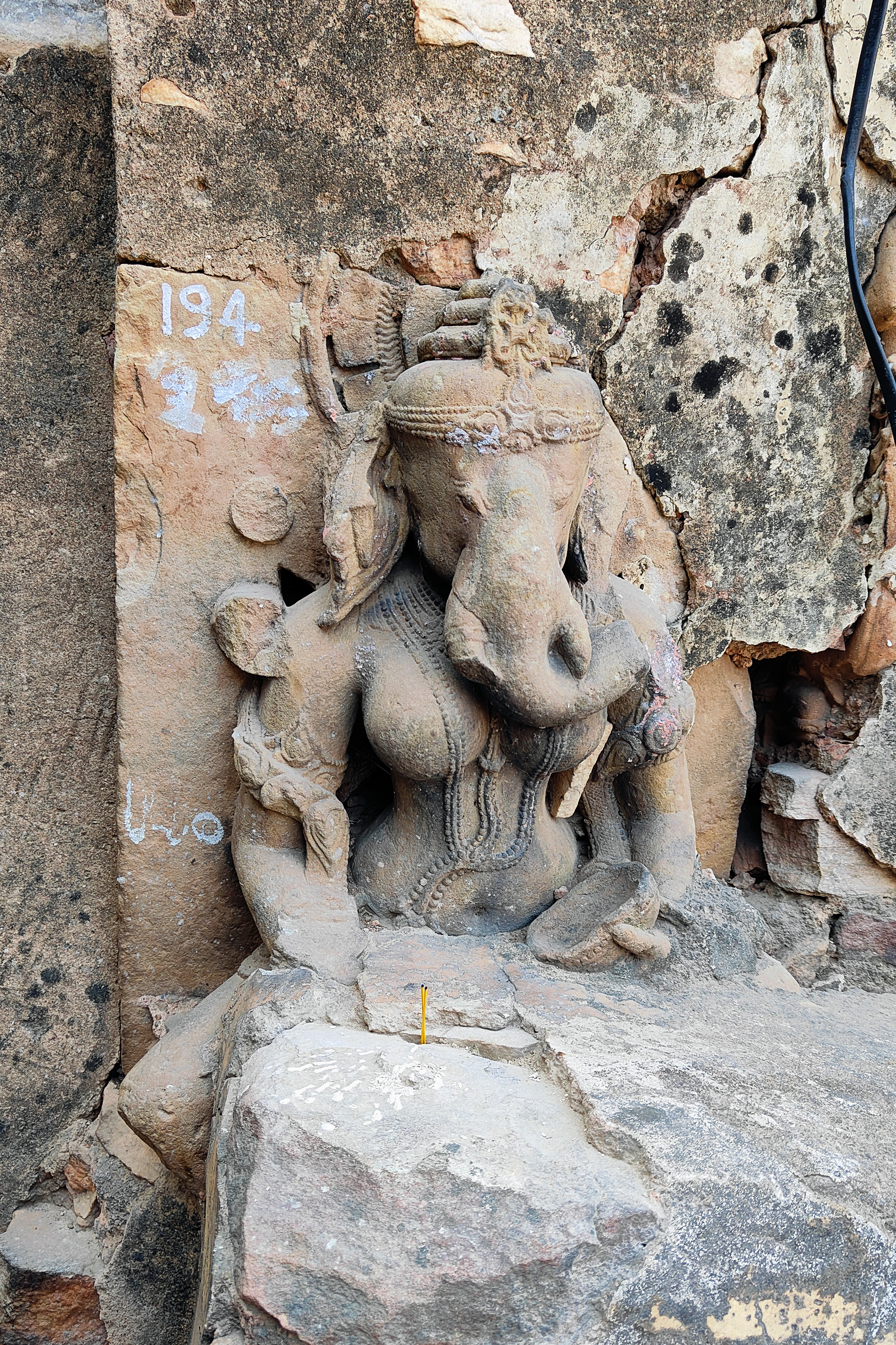 Image 14: This is a rare image of Vinayaki, the feminine aspect of Vinayaka or Ganesha (consort in some traditions). It is one of the several images once contained in the lost temples of the hill, which were later affixed on the walls of the Bhairon shrine complex. The stairs next to it have subsumed the lower portion of the image, leaving only a partial image visible.