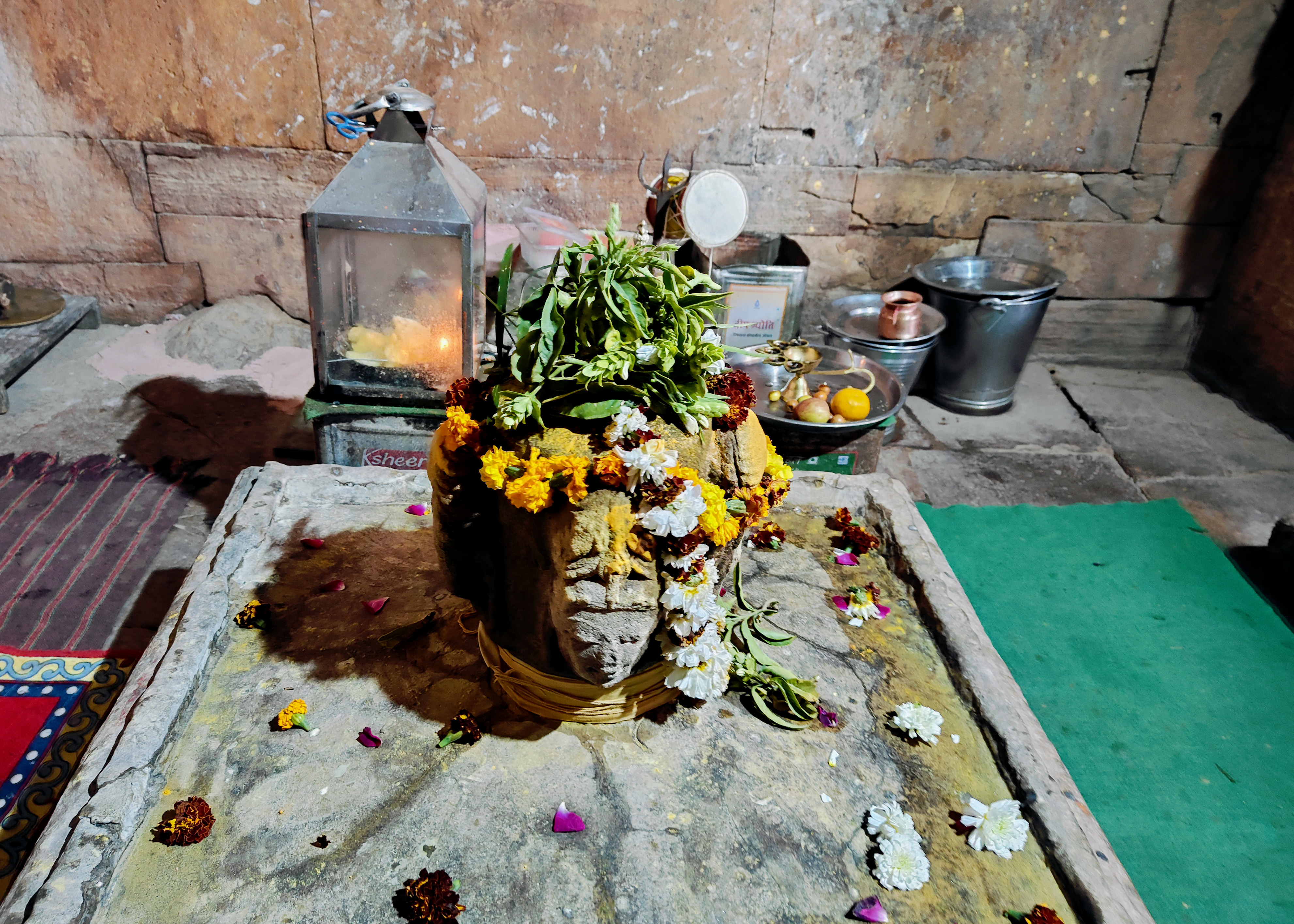 Image 18: The four-faced linga, placed in the sanctum of the Harshnath Temple, is actively worshipped at the site. It has three benevolent faces, while the one facing north bears a fierce expression. They collectively represent Shiva's Sadashiva form. The idol is contemporaneous to the main shrine, but there is some debate over whether it was the original cult image in the shrine or a later replacement.