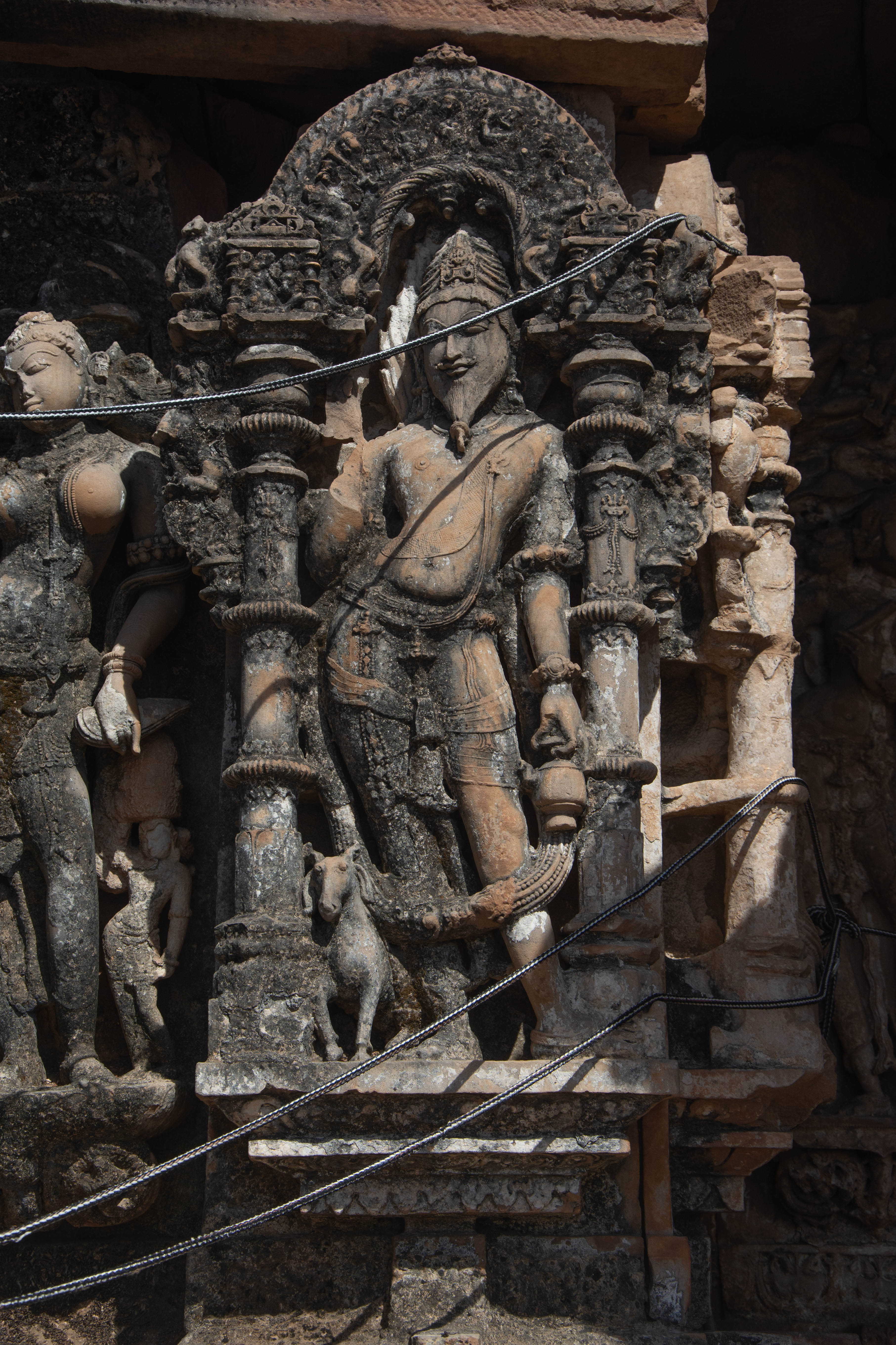 The Harshnath Temple features a figure of the dikpala Agni at one of its karna (corner projections). The figure of the dikpala Agni is situated on the karna of the southeastern corner, accompanied by his vahana, a ram. On either side of him, surasundaris occupy places at the pratirathas and salilantara-recesses.