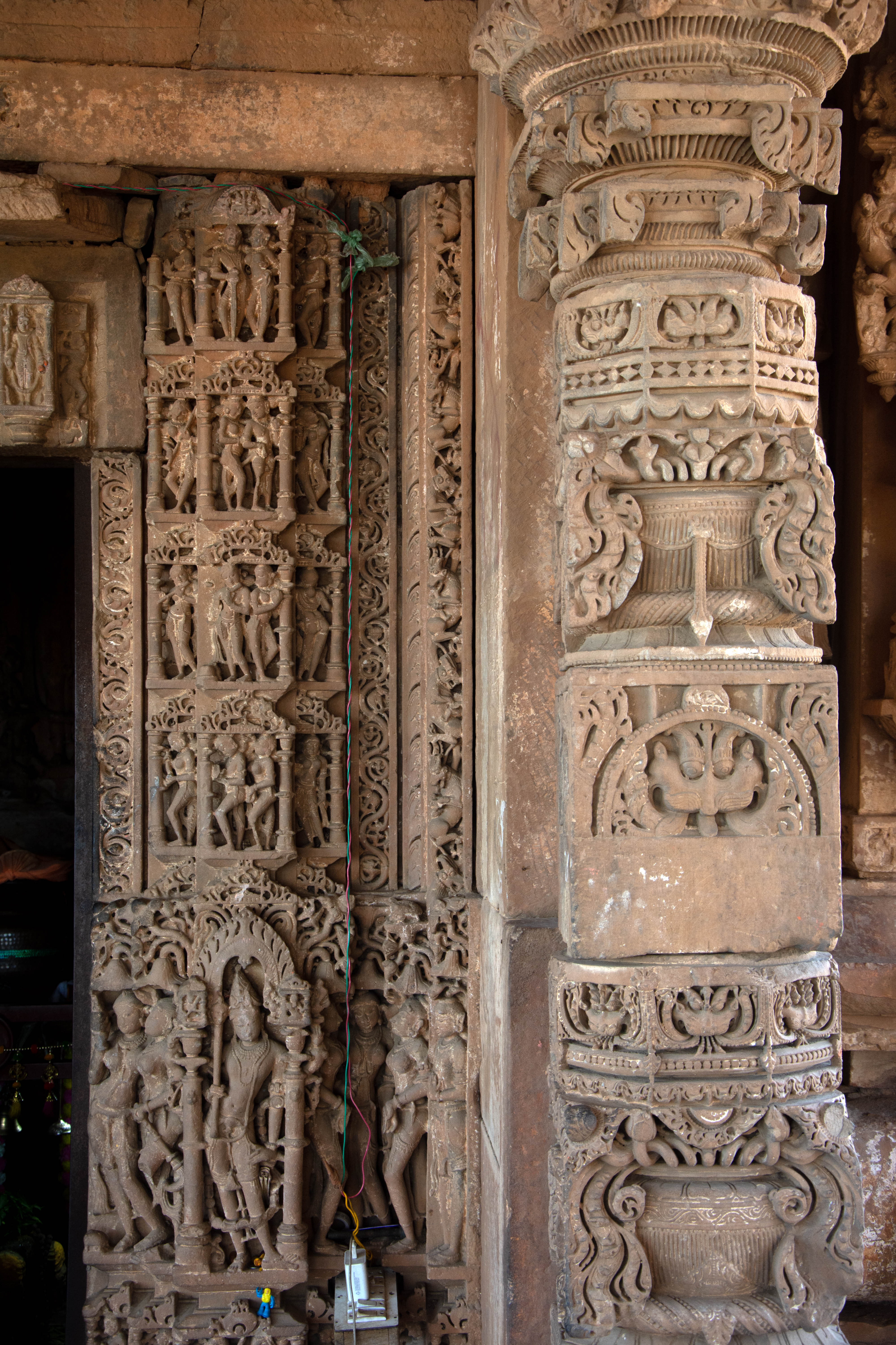 The garbhagriha's doorway is made up of five panchashakha (jambs) from the Harshnath Temple. Pairs of dvarapala (door guardian) and river goddesses (Ganga-Yamuna) occupy their standard positions at the bottom of the jamb. Carved on either side are Mithuna figures in their typical positions.