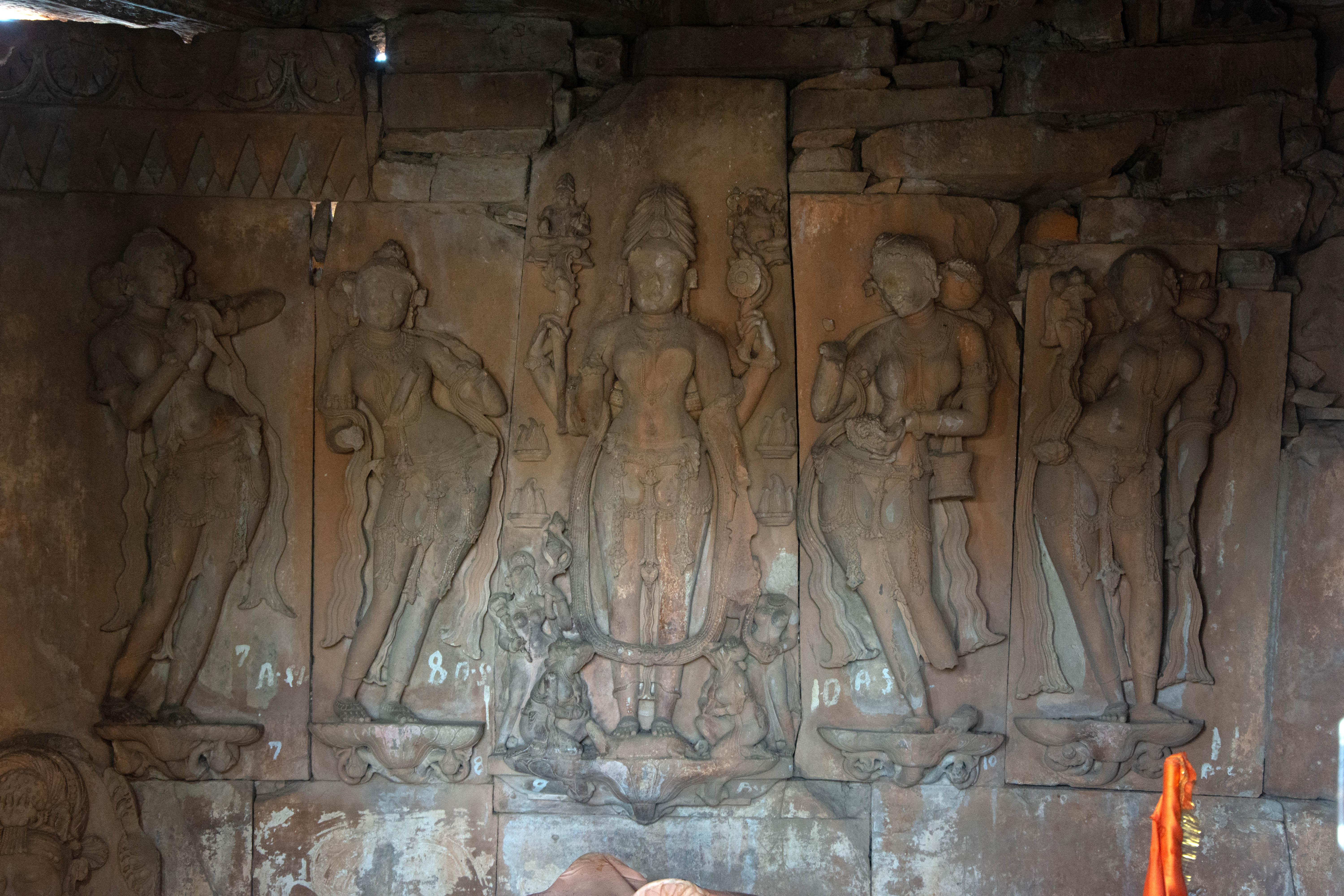 Inside the sanctum of the temple, beautiful sculptures of nayikas (female dancers) adorn the walls. The panchagni tapa, a colossal image of Parvati in penance, stands at the center of the principal/back wall. She stands erect on an iguana and is hence labelled as Godhasana Gauri. On either side of her, there are two standing and two sitting female attendants.