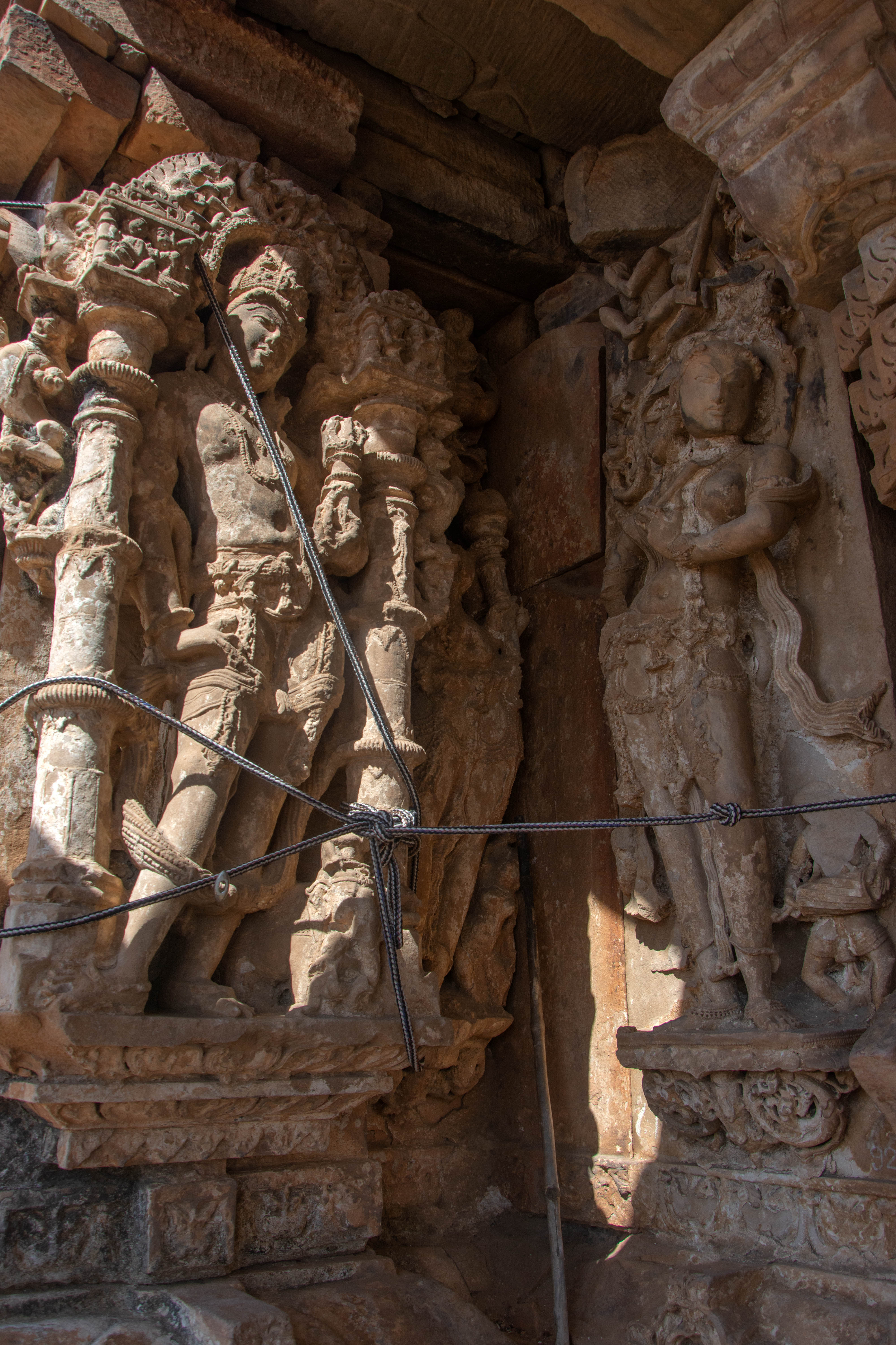 A surasundari stands on the antarala, holding a flute. At the bottom, there is a dwarf holding a drum. In the adjoining recess, there is another image of a surasundari.