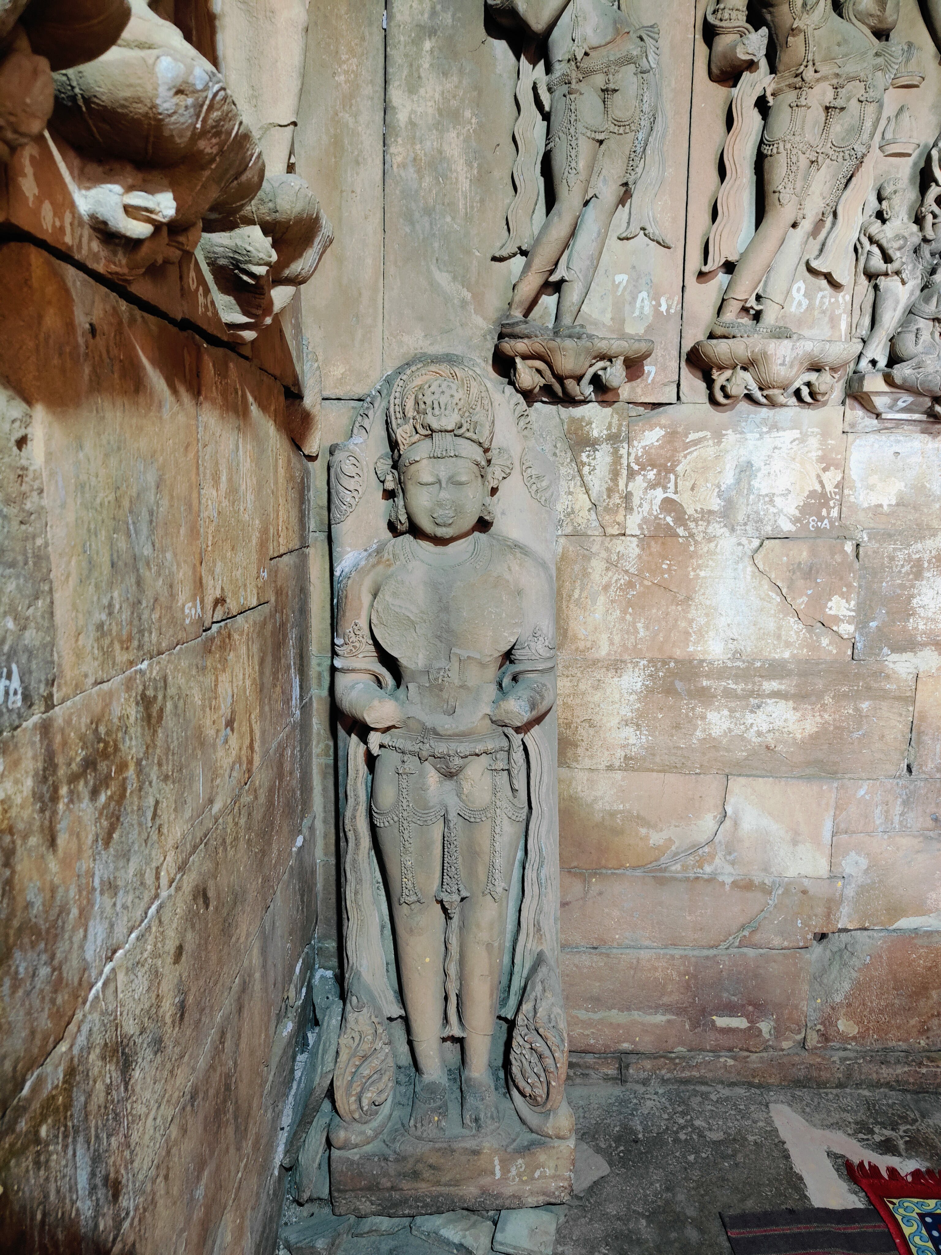 A life-size female figure stands erect in the sanctum of the Harshnath Temple, her hands broken, possibly in a gesture of veneration. Her identity is unknown.