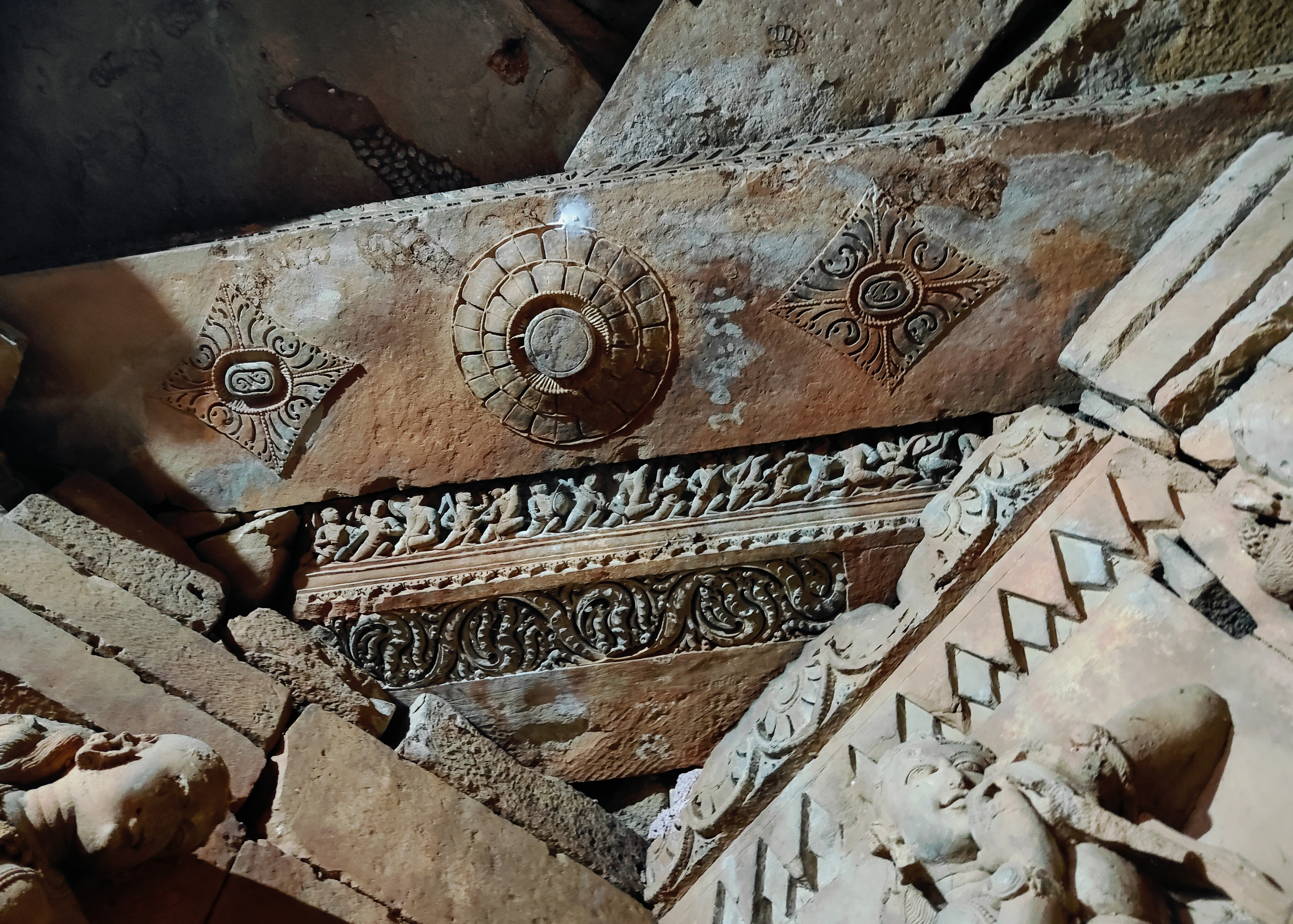 The ceiling beam in the sanctum depicts an array of warriors marching towards its right side, while the lower face of the beam is richly carved with vegetation foliage.