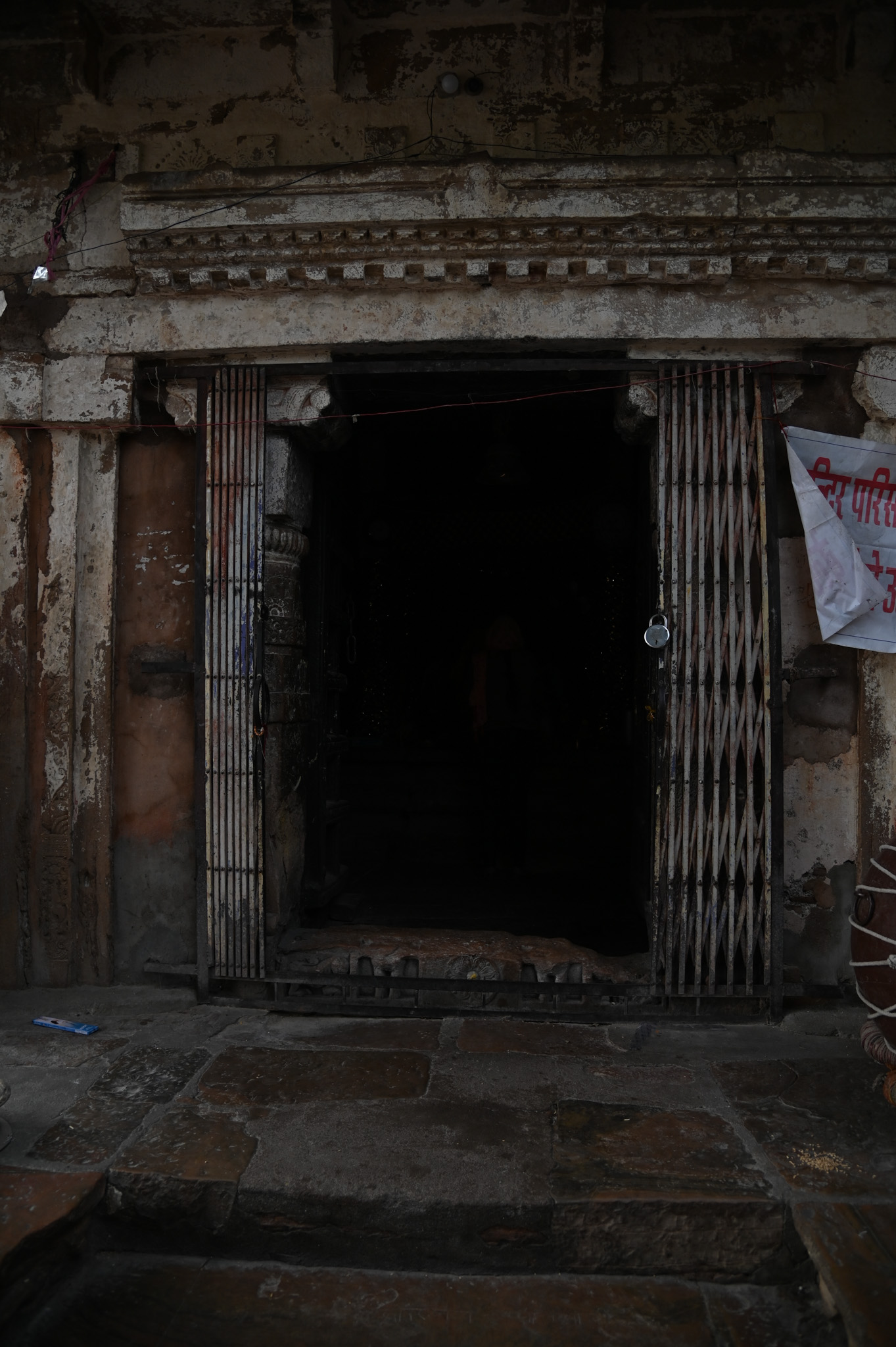 The current temple structure's east-facing entrance is visible. Only close inspection reveals the carved figures at the bottom of the doorframe, which have faded over time. The upper section of the doorframe, known as the uttaranga, bears a resemblance to a carved wooden roof.