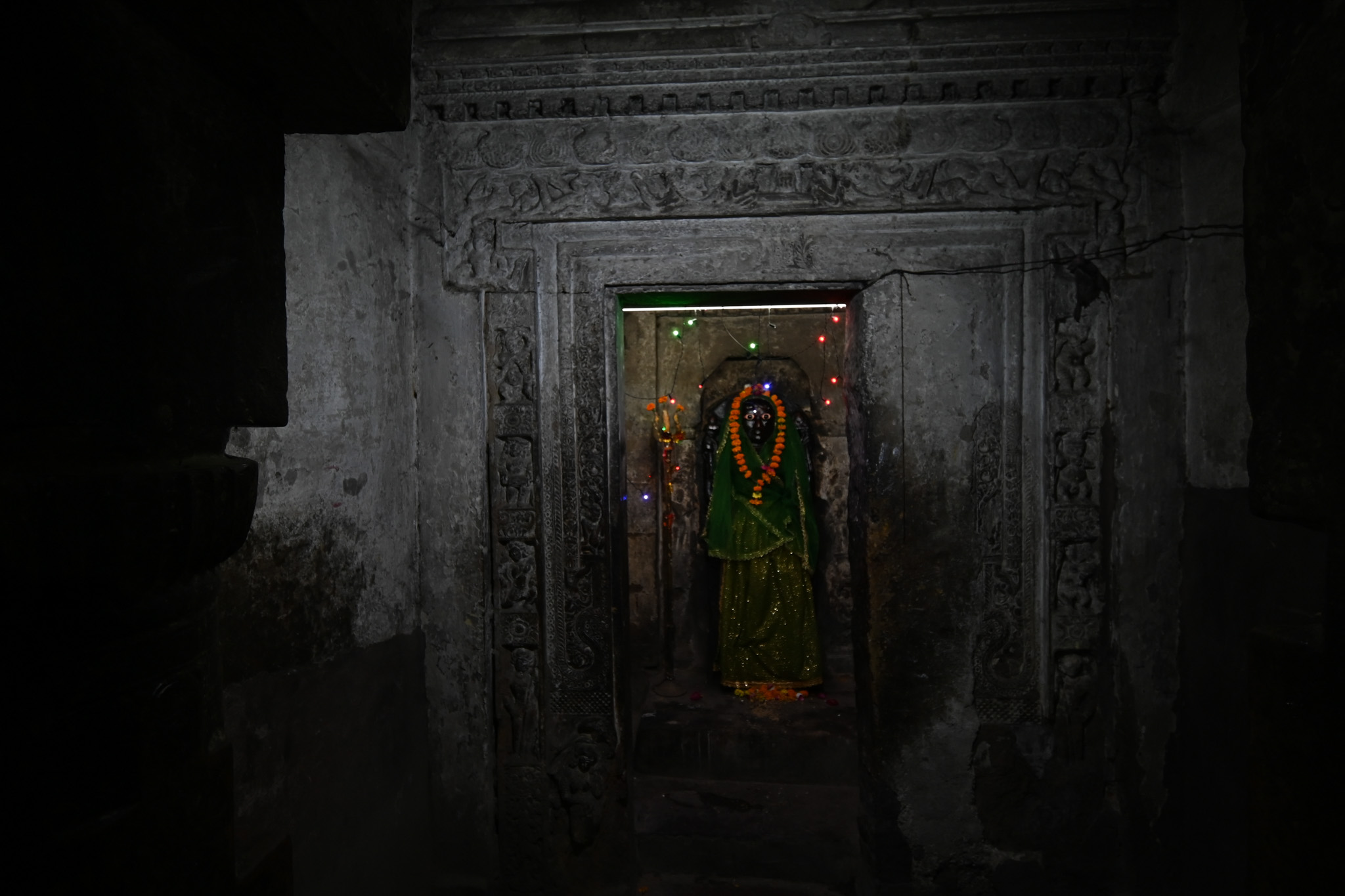 The temple's antarala (vestibule) is made up of four pillars. It is a rectangular, plain passage that connects the mandapa (pillared hall) and the garbhagriha (sanctum sanctorum). This section of the temple structure dates to the Gupta period, as evidenced by the Gupta Brahmi inscription engraved on one of the pillars (on the right). The antarala leads to the garbhagriha, which has a beautifully carved T-shaped door frame, one of the characteristics of Gupta-period temples. The garbhagriha's doorframe features multiple shakhas, adorned with river goddess figures at the bottom, dwarf figures, and floral decorations above.