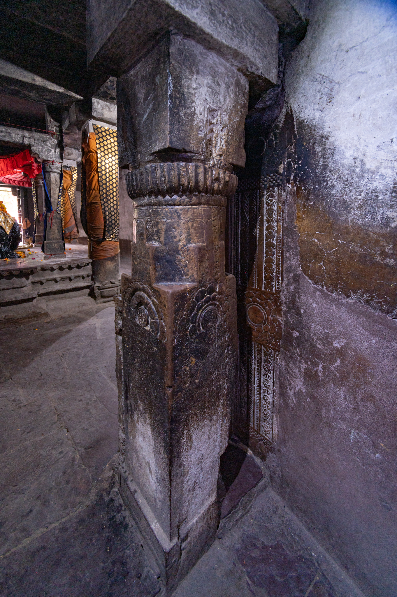 The antarala's pillars are supported by a square base. The half lotus medallion sculpts the middle square shaft. Above this medallion, the shaft turns circular, topped with an amalaka and a plain square abacus.