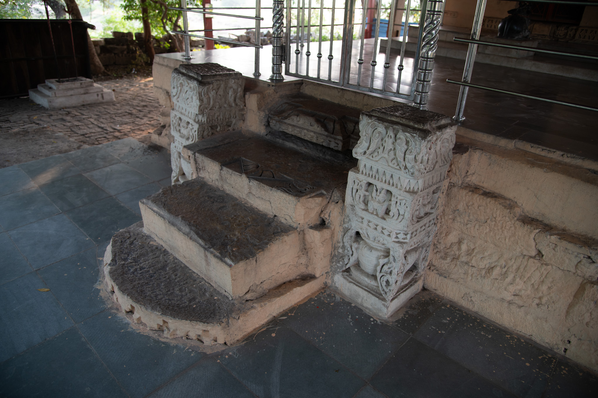 Upon closer inspection, the stairs leading to the mandapa resemble the chandrashila (moon stone) found in ancient temples, despite the lack of carvings on the bottom stair. During the renovation, the original broken parts of the temple decorated the top two stairs. Both sides of the steps feature pillars resembling those at the temple complex's entrance.