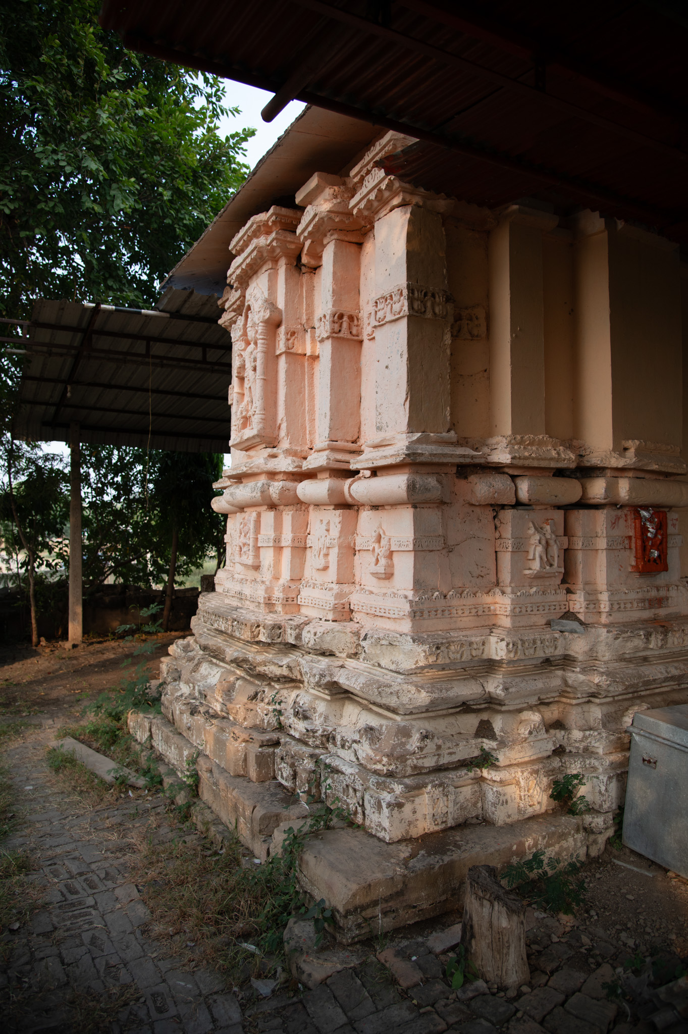 The garbhagriha shows the vedibandha and jangha on its vertical axis. The vedibandha is made up of various mouldings, such as pitha, kapotapailka, karnika, grassapatta, manibandha, gaggarika, kumbha, and kalasha. The jangha has a bhadra and karna, and a horizontal band at the centre runs across the wall.