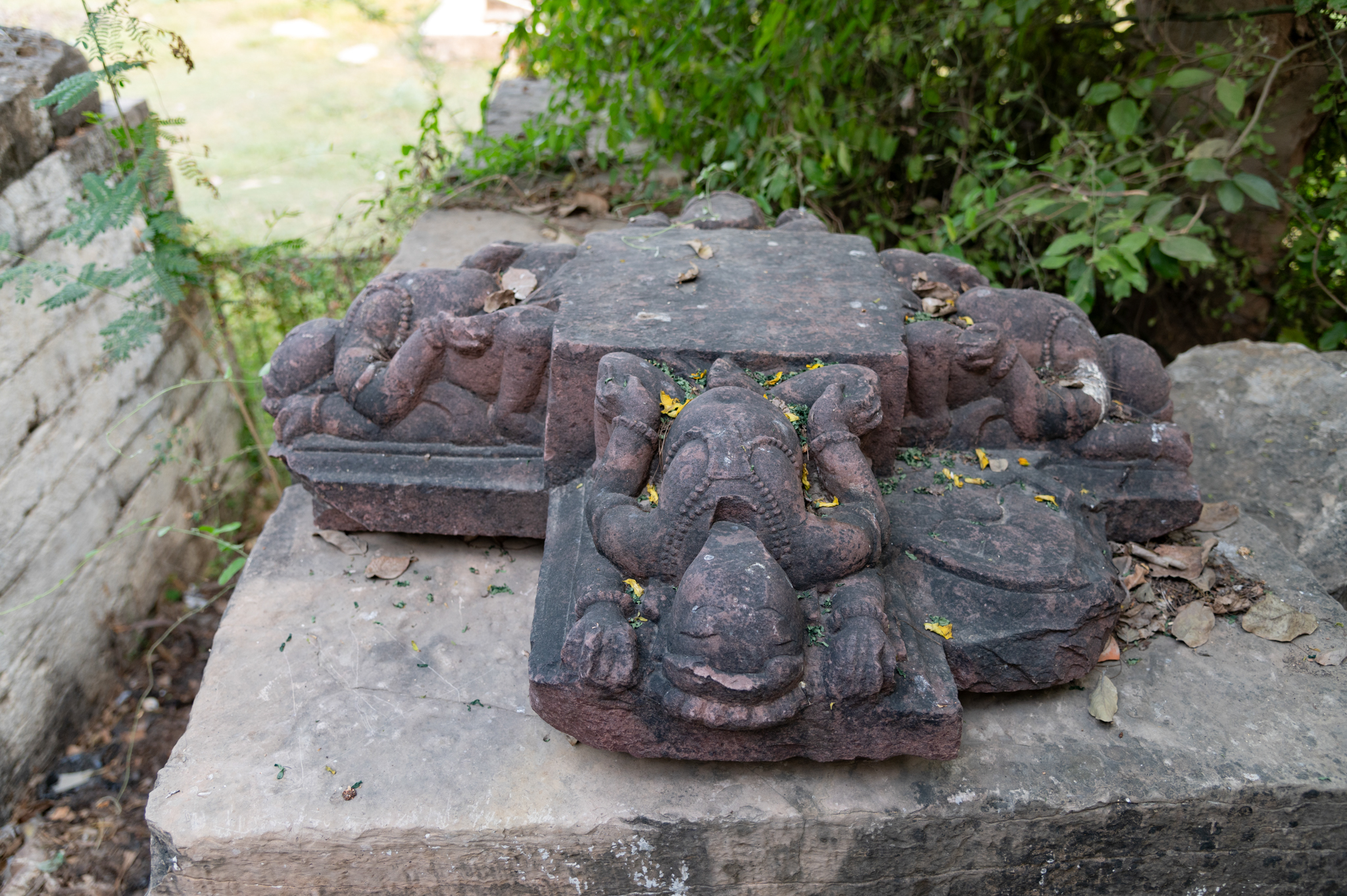 Near the frontal entry point, there is a fragment of a heavy pillar. The fragment is a pillar bracket, which depicts four bharavahakas (load bearers) on each side. These bharavahakas are four-armed and adorned with beautiful jewellery.