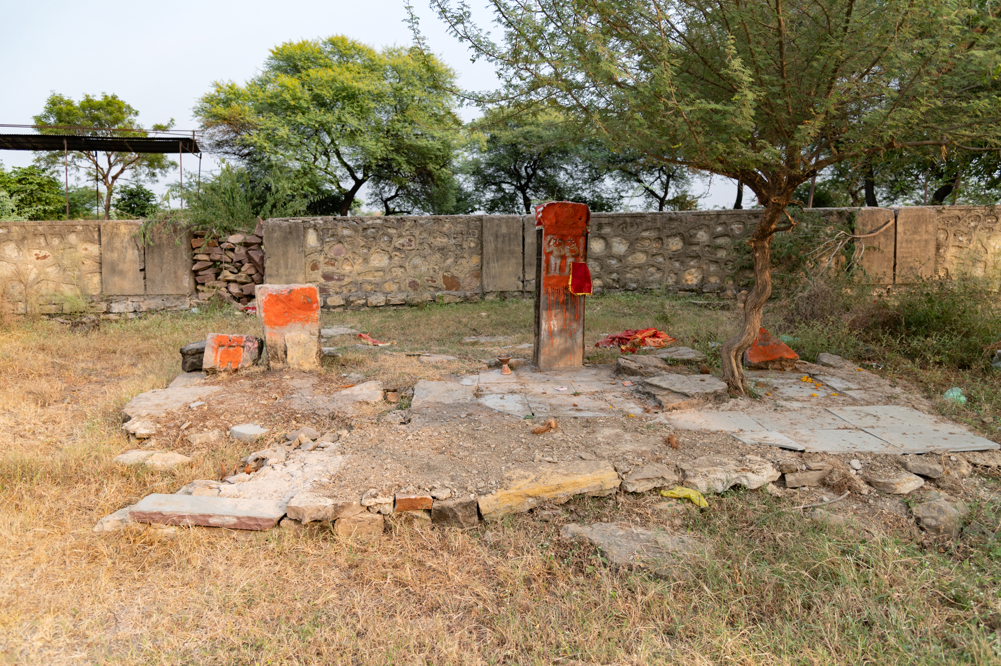 Near the Mahakal Temple, a memorial stone stands in front of the temple's west entrance. The stone features two vermilion-covered figures.