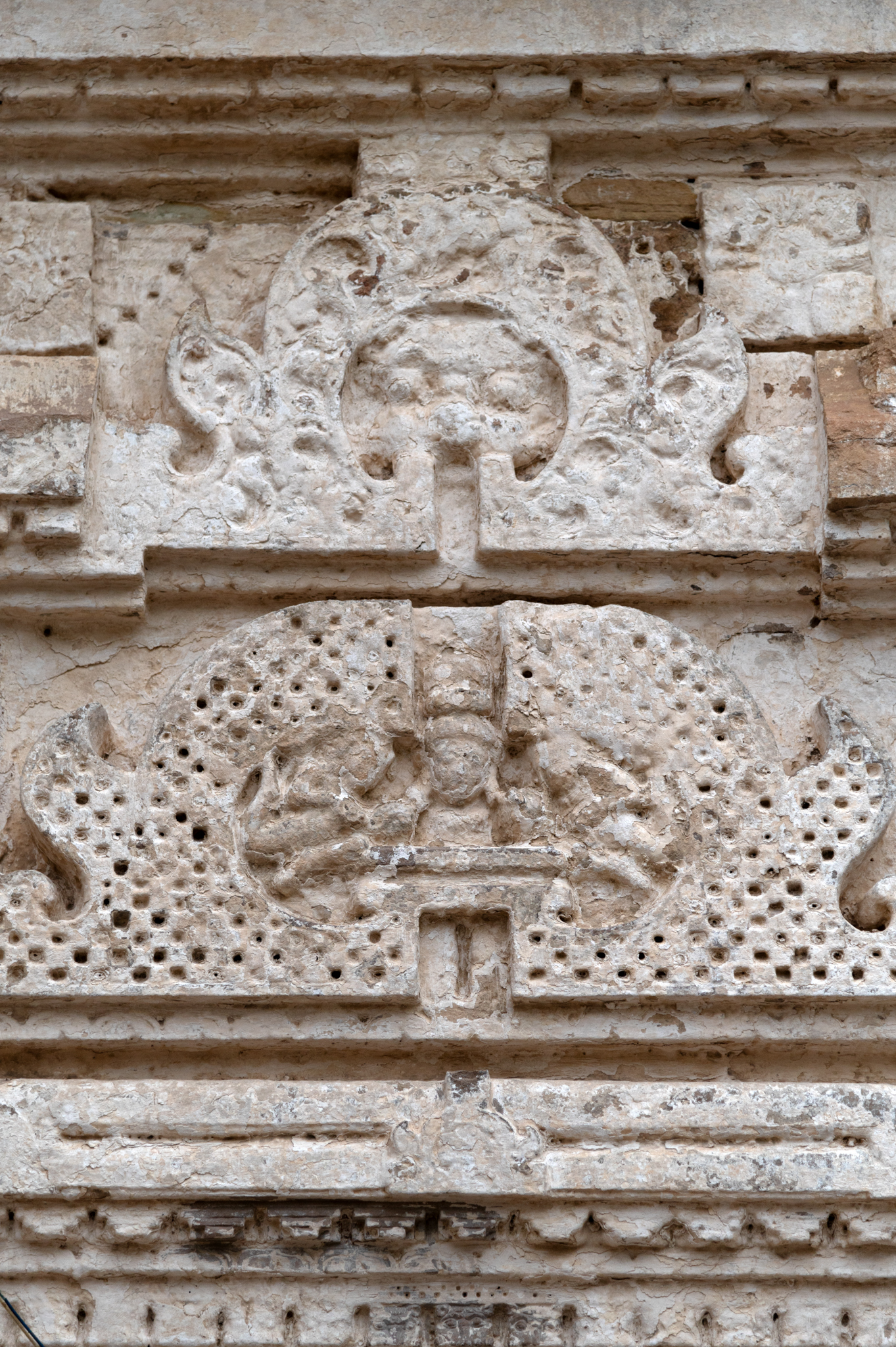 Image 9: Double chaitya arches top the windows on the side walls of the garbhagriha. The lower chaitya arch depicts the bust of a deity flanked by two celestial beings. The upper chaitya arch shows a grassamukha.