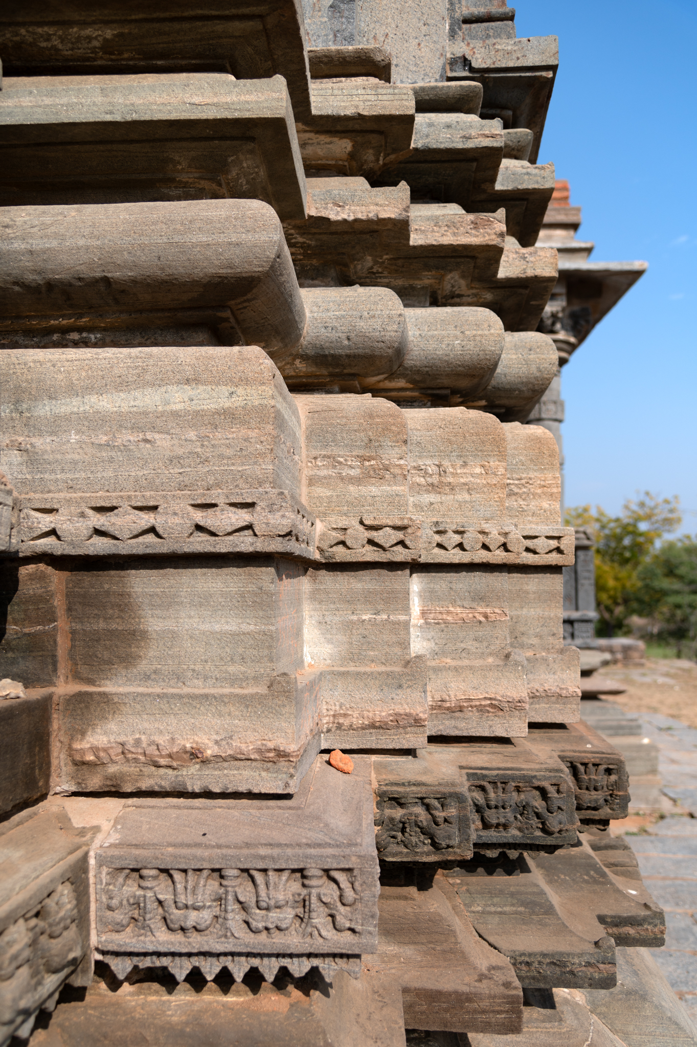 The temple's vedibandha (basal mouldings) feature intricate details. The broad kumbha (pot) moulding consists of a diamond motif band at its centre and a kirtimukha (face of glory) moulding at its base. Most of the plinth’s mouldings are plain.