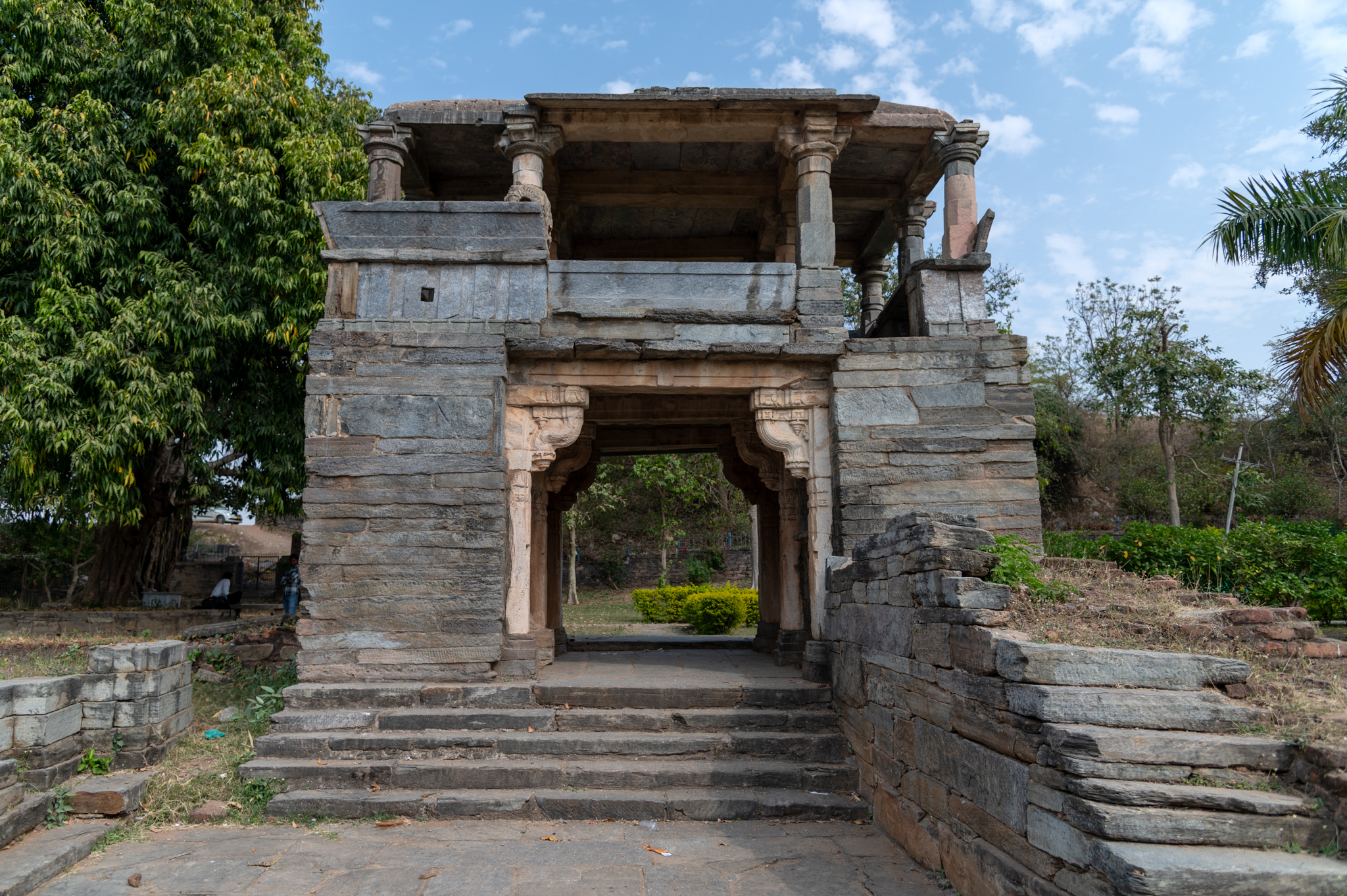 This is a gateway to the Hanuman Garhi temple complex. Behind this complex, the remains of an old fortification wall were found. This gateway is a semi-open space, with smaller niches on its exterior and interior walls. This gateway was probably a later addition to the temple complex, built entirely of stone.