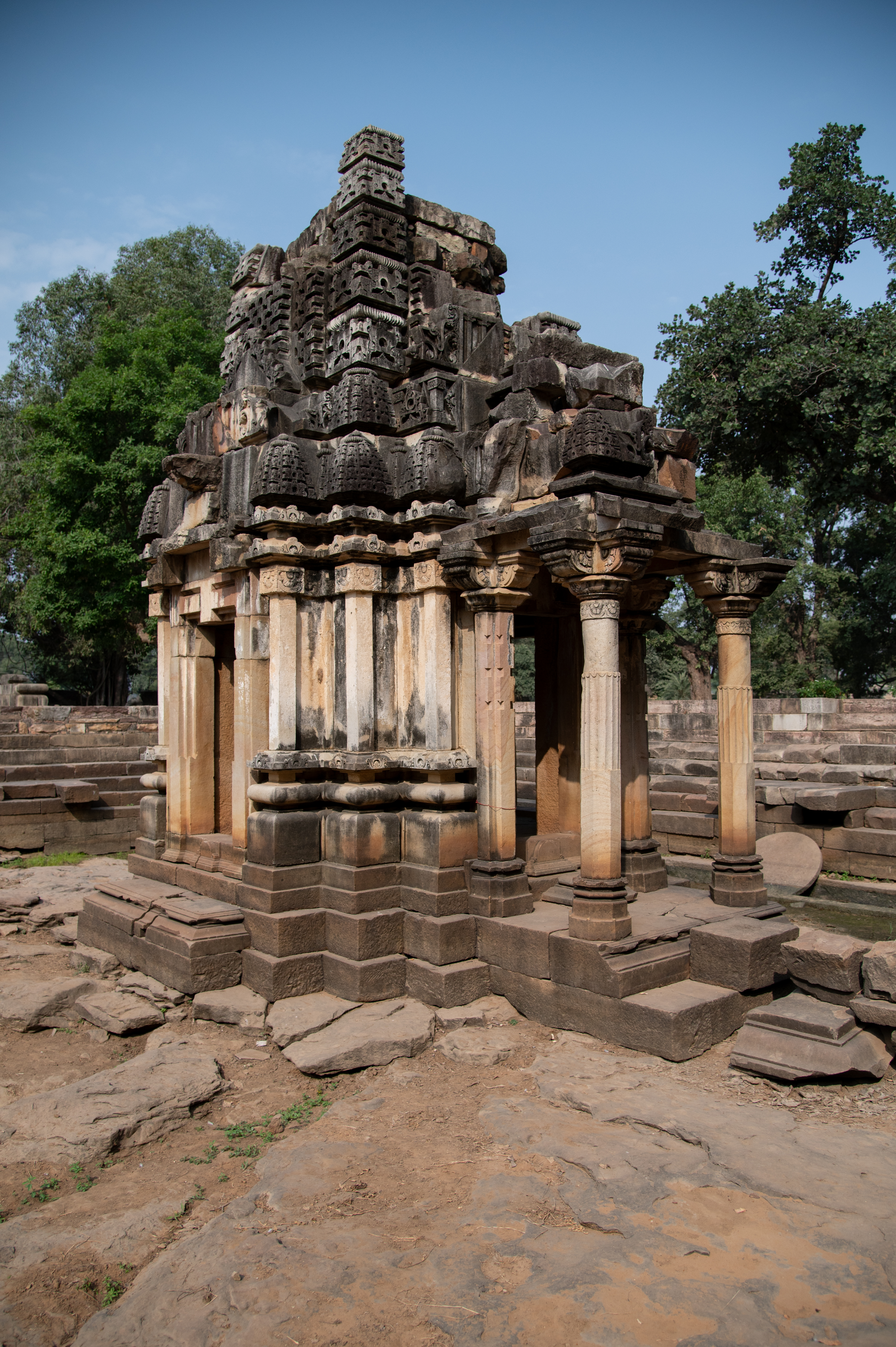  The temple has a pitha (a small platform) and vedibandha (basal mouldings) that includes a khura, kumbha (pot-shaped), kalasha (a pitcher), antarapatta (recesses between mouldings), and kapotapalikas (cyma recta mouldings). The jangha (wall) is plain, with the gates carved at its centre. The shikhara (superstructure) above the varandika (moulded parapet) features an anekandaka shikhara (multispired superstructure) with surasenaka (miniature spires) on all four sides.