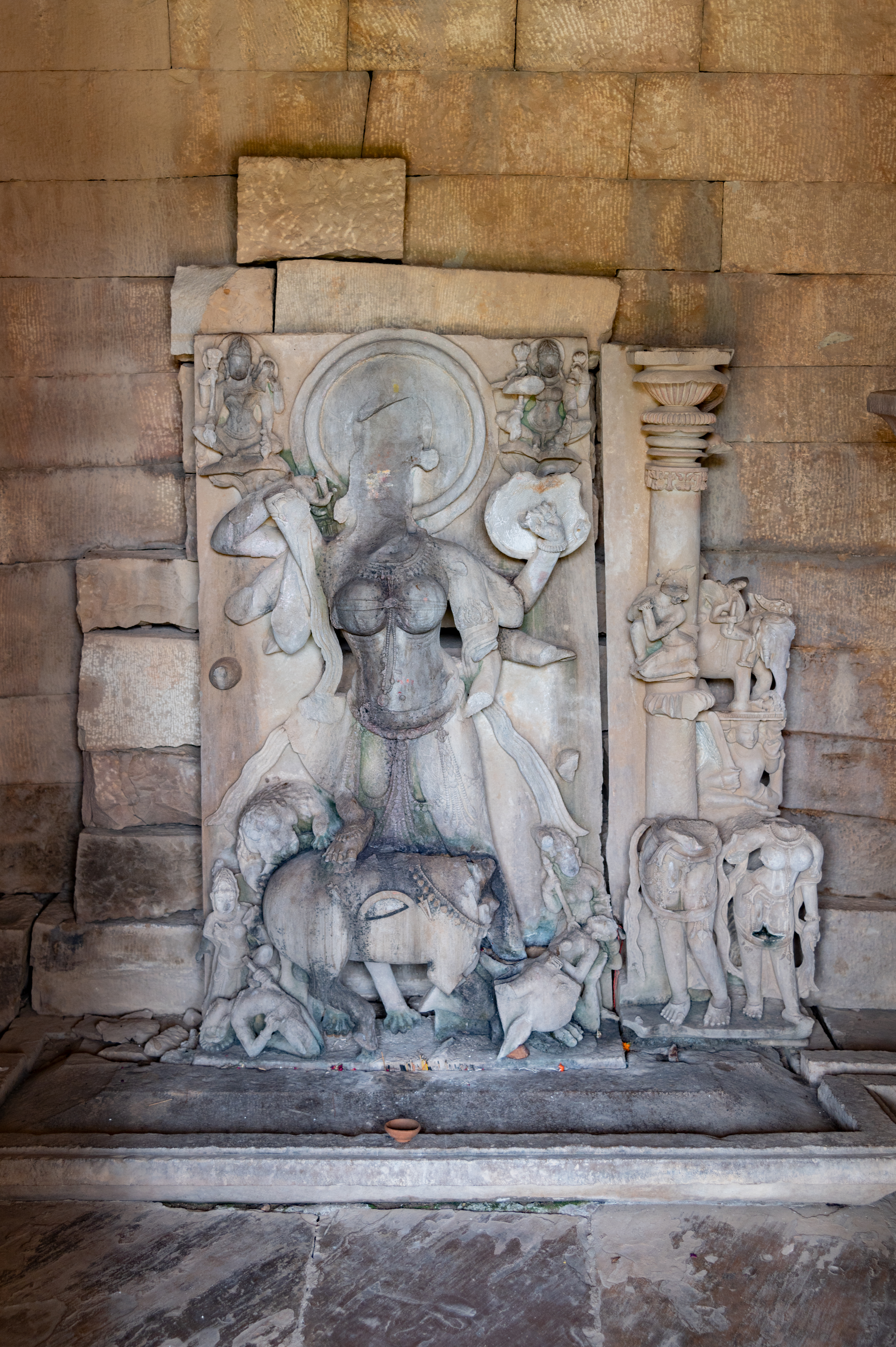 The sanctum of the temple has a sculpture of Mahishasuramardini sculpture. The multi-armed Goddess is shown slaying Mahisha (the buffalo demon), who is depicted in zoomorphic form. Presently, her head and arms are broken. She is accompanied by a few figures who are also seen killing asuras (demons). Her vahana (mount) is also depicted.