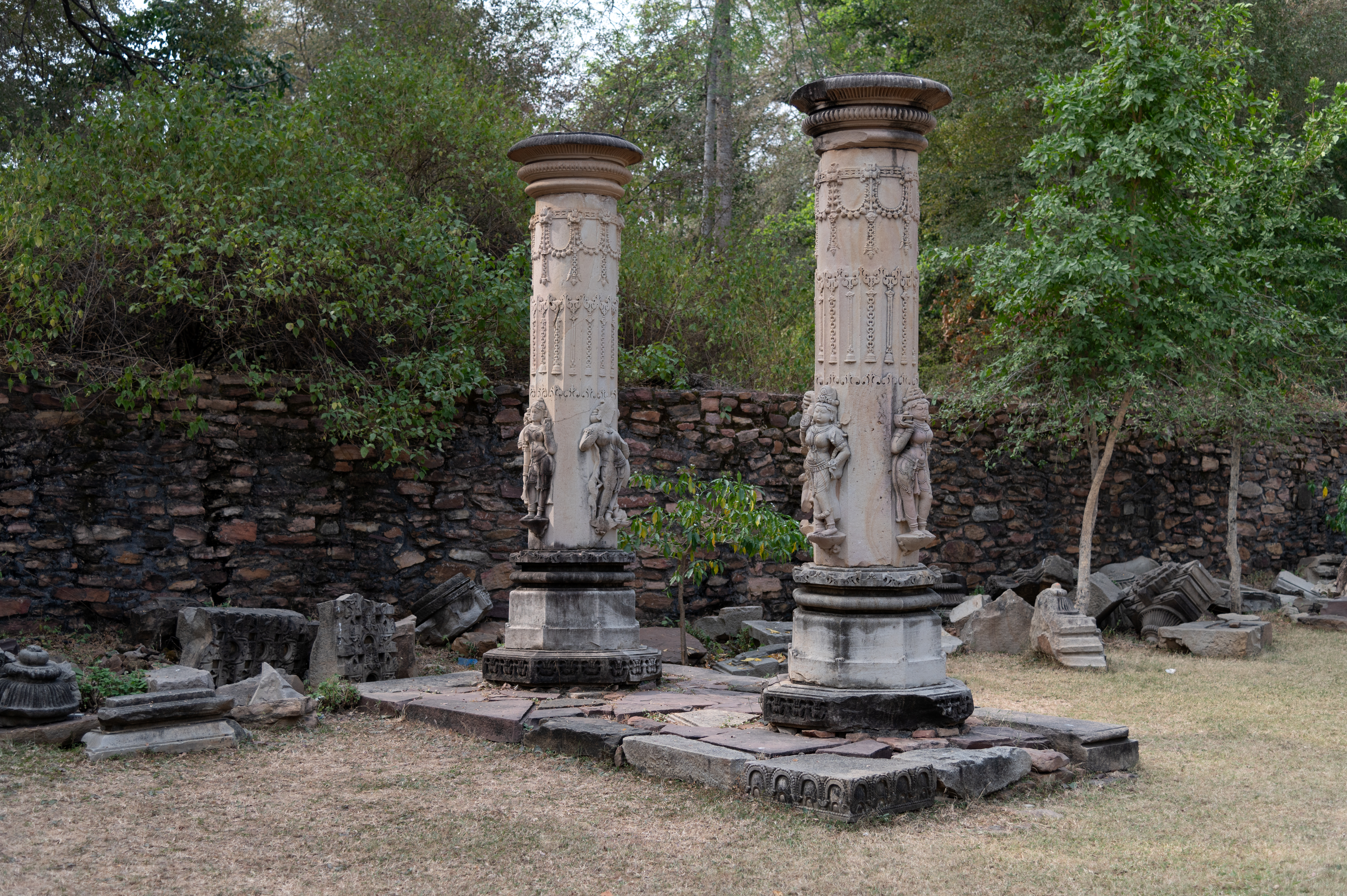 The temple complex has an ornate torana (ornamental gateway). While the arch of the torana is broken, the pillars are still well-preserved. Each pillar depicts three female figures and one male figure on the lower octagonal part of the shaft. The upper portion of the pillars is adorned with loops and chains of bells.