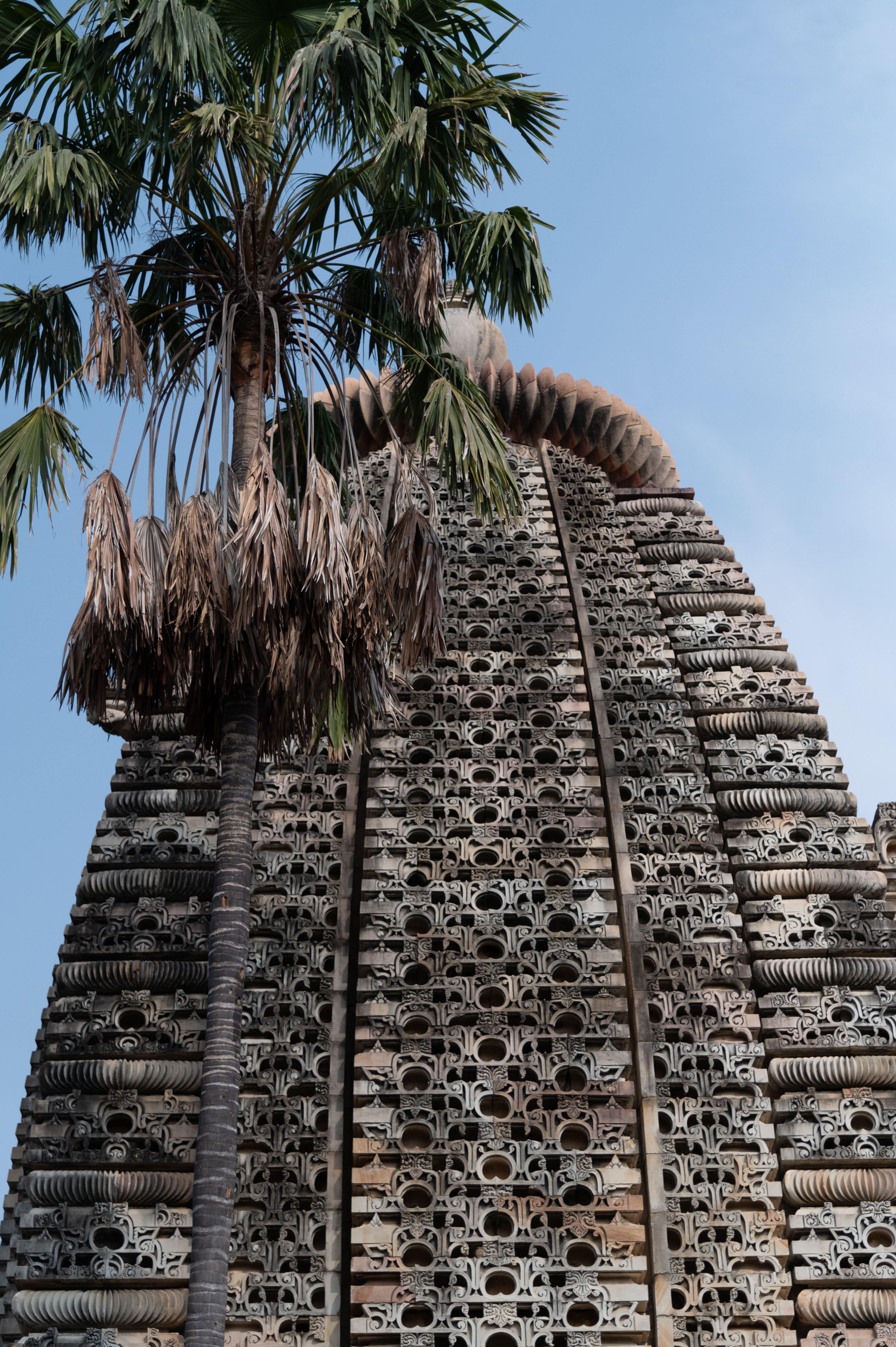 The shikhara (superstructure) of the garbhagriha (sanctum sanctorum) is made in the latina (vertical mono-spire) style. The bhadra (central offset) and pratibhadra (offset flanking bhadra) of the shikhara are profusely carved with chaitya (dormer windows) arches, and the karna (corner offset) is decorated with chaitya arches and amalakas (crowning member of the latina shikhara shaped like a myrobalan fruit).