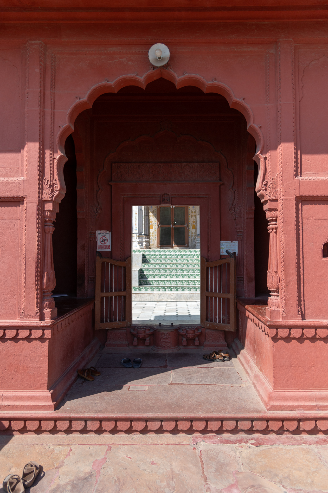 The foliated archway with fluted pilaster column motifs on either side leads into the temple. Beyond the archway are two transepts puncturing the inner walls of the entrance gateway.