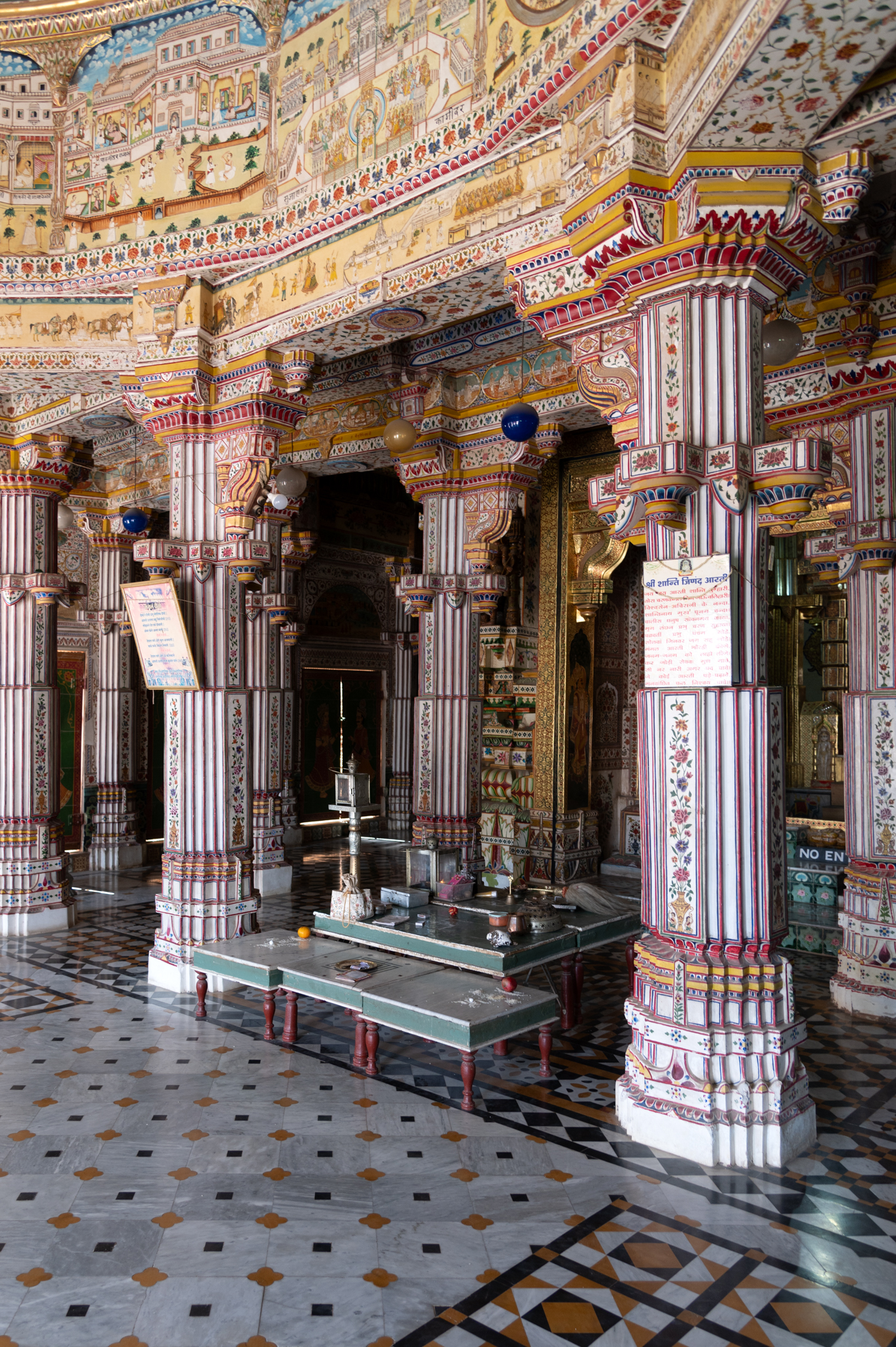 Closer view of the painted pillars in the mandapa (pillared hall) of the Bhandasar Temple. Between the two central pillars near the antarala (antechamber), there is a low pedestal where devotees perform their daily rituals.