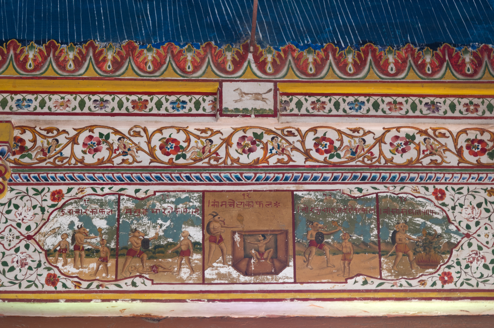 This is a painting panel on the beams of the mandapa (pillared hall) of the Bhandasar Temple. It is a set of five paintings drawn for the purpose of informing the people about the wrongdoings that should be avoided. In every painting, a demonic figure is shown punishing the person who has violated moral laws. The five paintings have inscriptions of the acts that Jainism condemns. These are, ‘Kamchesta ka phal, Manushya ko maarne ka phal, chor ko saahaj dene ka phal, Biswas ghat ka phal’ (punishments for indulging in wrong sexual activities, killing a human being, supporting a thief and betrayal).