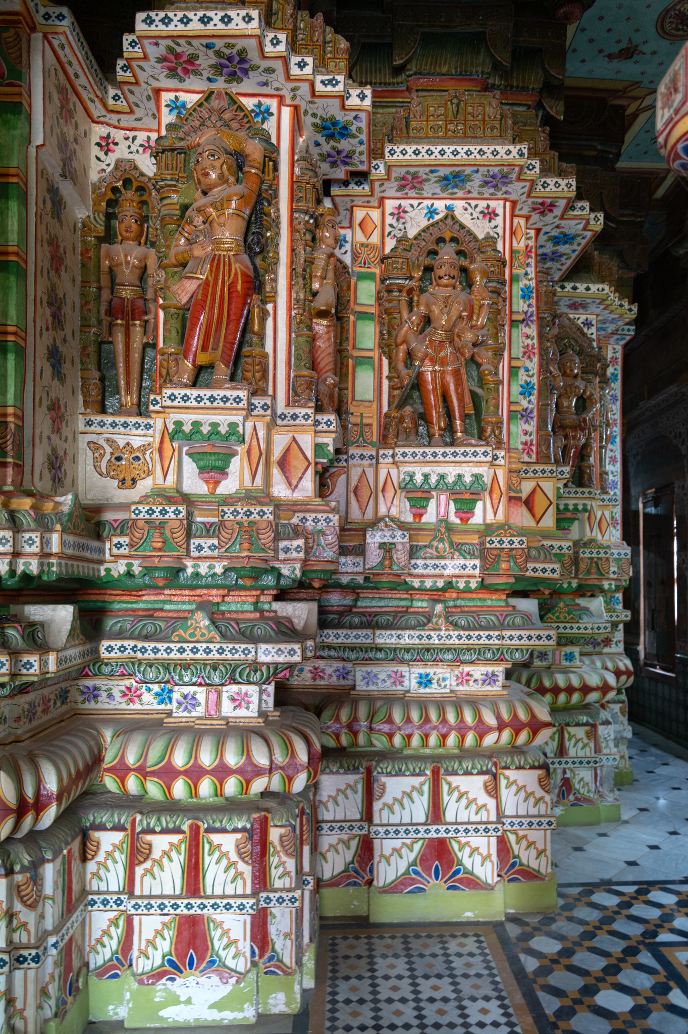 Closer view of the elevation of the garbhagriha (sanctum sanctorum) of the Bhandasar Temple. The two projections visible in the picture, show few basal mouldings of the plinth are covered in the later added flooring. From the remaining portions, from bottom to top, the mouldings are kumbha (pot), kalasha (a pitcher) and kapotali (cyma recta) of the vedibandha (basal mouldings). This is followed by the jangha (wall) that further connects to the cornice of the temple.