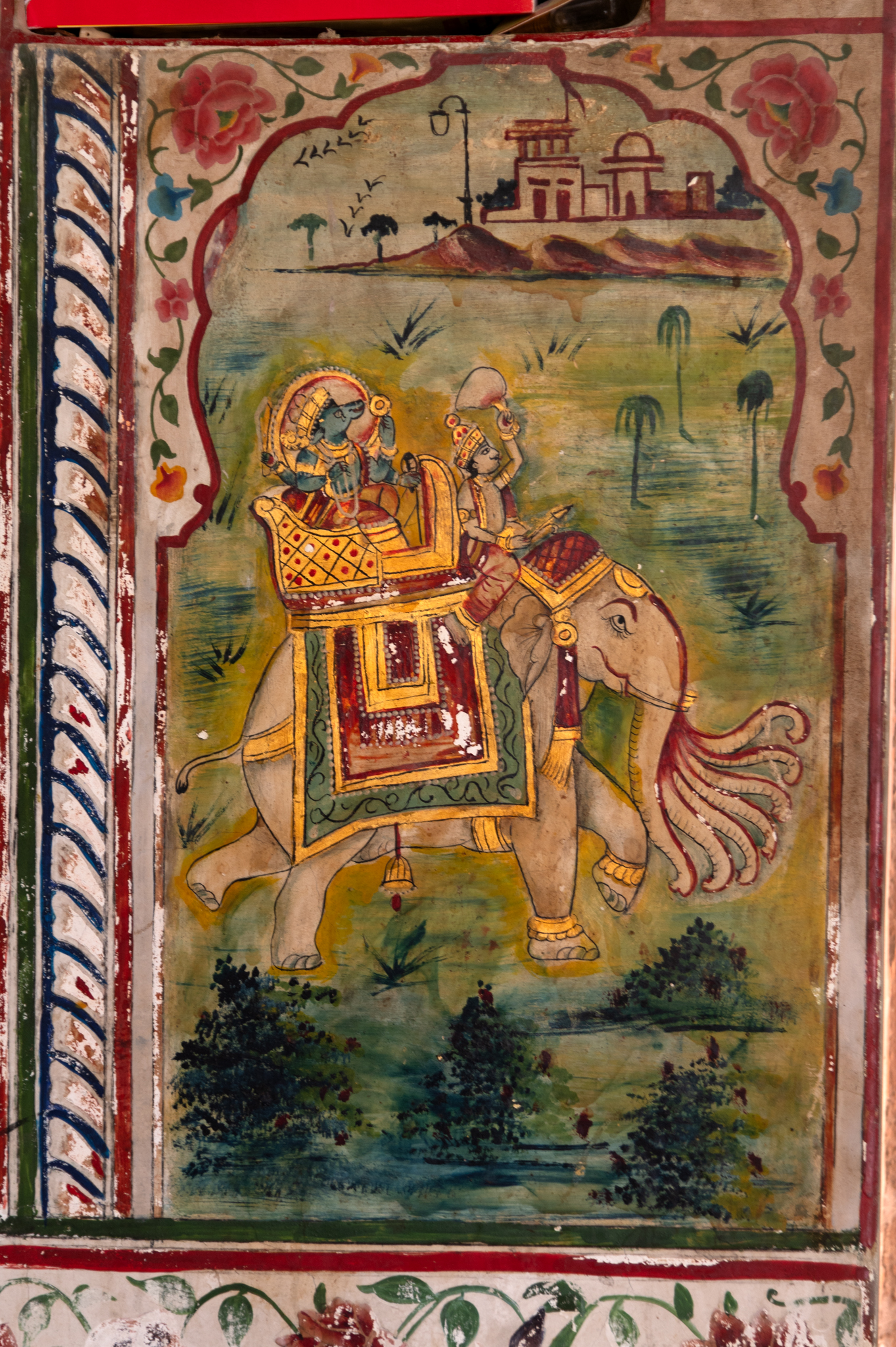 Closer view of one of the paintings that frame the side doorways on the mandapa (pillared hall) of the Bhandasar Temple. Seen here is the painting of Vishnu sitting on an elephant. A mahut (charioteer of the elephant) is shown riding it in the city. The elephant has multiple trunks. The jewellery worn by Vishnu, the elephant and the canopy, in which Vishnu is shown sitting on the elephant's back, are embossed with gold.