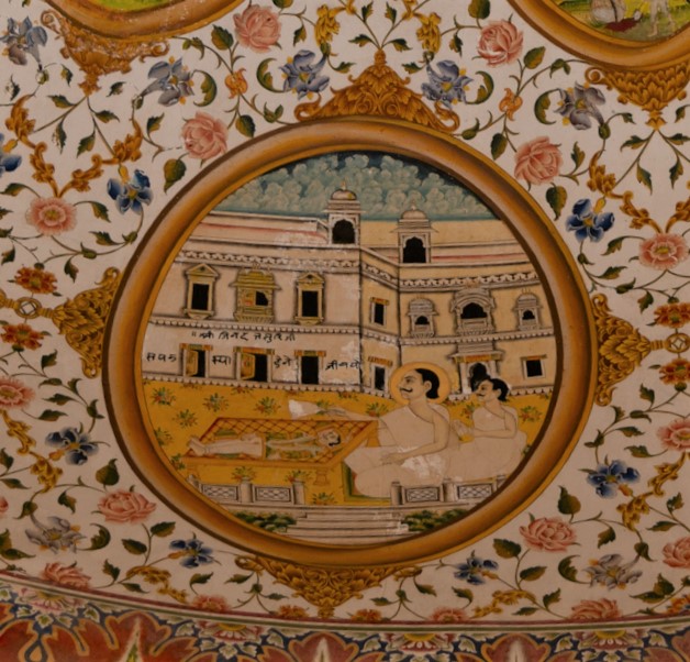 Jinadatta Suri is depicted here with his disciple, who is curing a person of his ailment. The acharya (those who impart knowledge) is renowned for such miraculous deeds. This seventh oval painting (in clockwise order) in the lower/outer circle in the ceiling of the mandapa (pillared hall) is the last of four paintings dedicated to the miracles of Jinadatta Suri, through which the acharya saved several lives. The inscription reads, ‘Shri Jinadatta Suriji sapata spa dene ji vayo.’