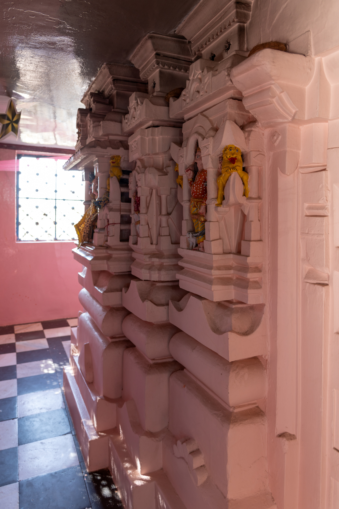 Seen here is the exterior wall elevation of the Suswani Mata Temple. Few of the base plinth mouldings are buried; however, the mouldings of the vedibandha (basal mouldings) are visible in the order of khura (hoof), kumbha (pot), kalasha (a pitcher), kapotapalika (cyma recta), followed by the jangha (wall) portion. The part connecting the garbhagriha (sanctum sanctorum) to the mandapa (pillared hall) is abruptly cut during the modern period restorations. Kumbha moulding with motifs, pancharatha (five ratha or projections on each side) plan with bhadra (central offset), pratiratha (intermediary projection or offset) and karna (corner offset) are visible.