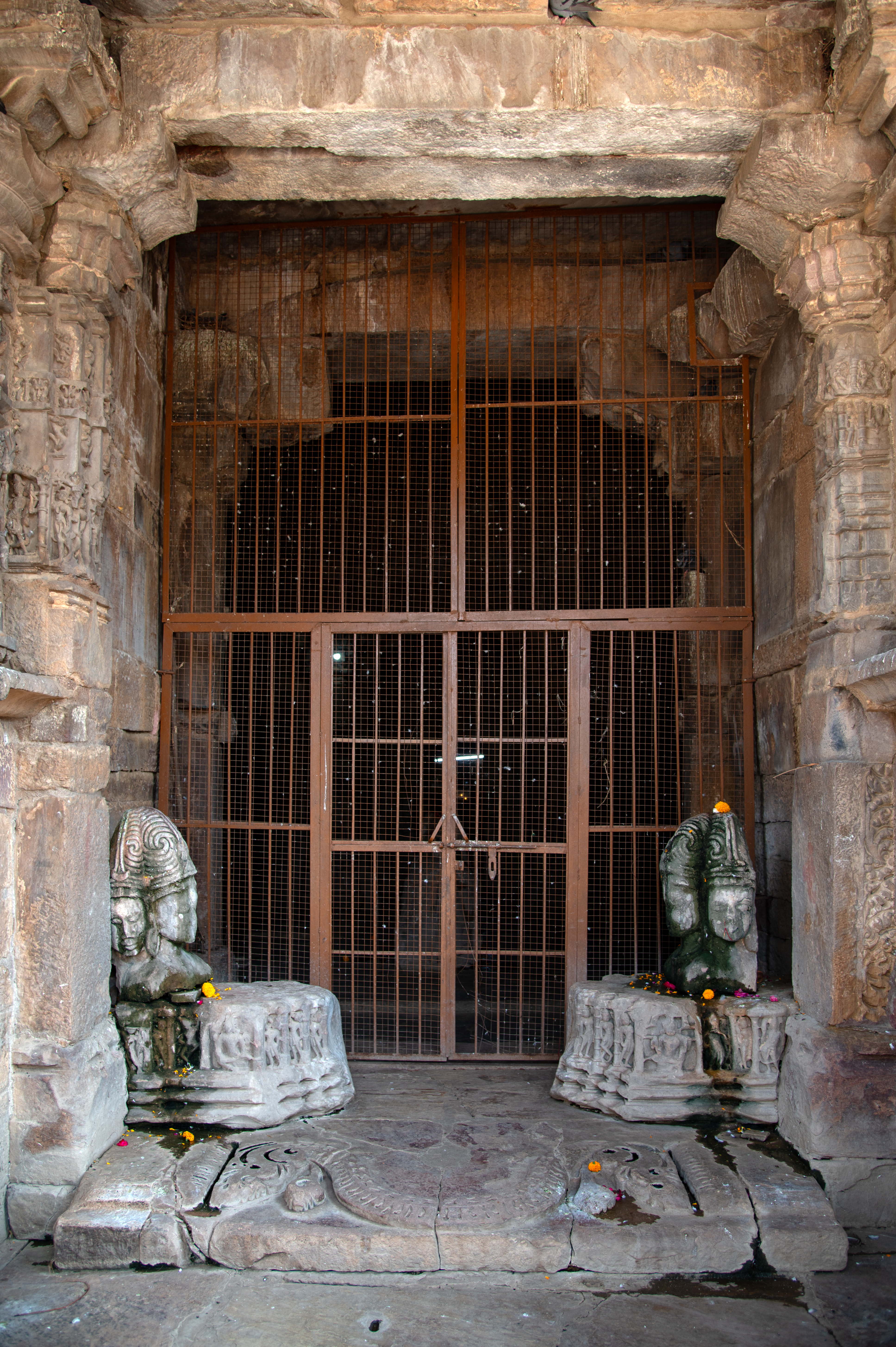 The passage from the mukhamandapa (front porch) leads to the mandapa (pillared hall), marked by two detached busts of Sadashiva at both sides of the entrance. Each bust portrays Sadashiva with three faces.