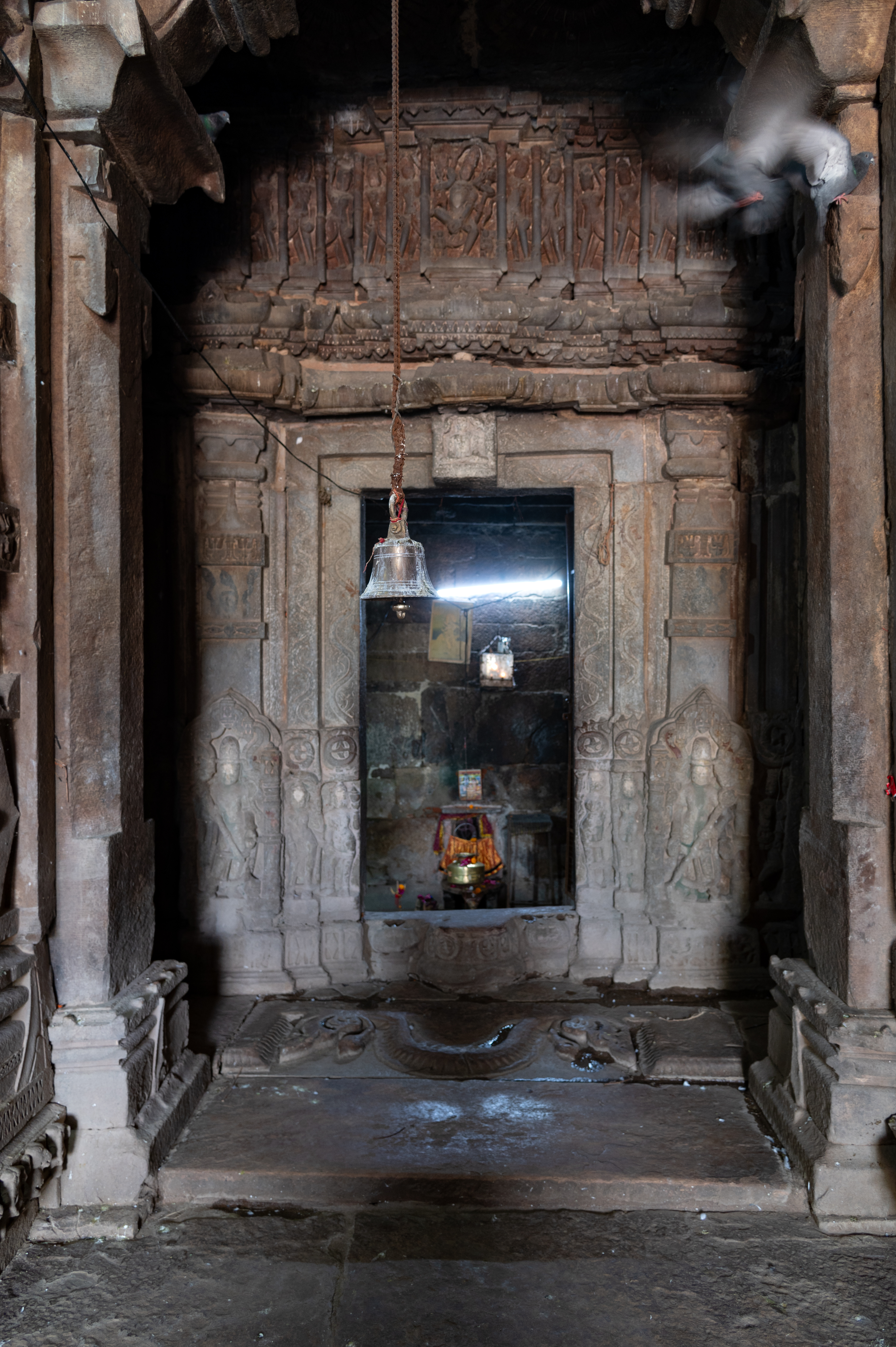 To the east, there is the main garbhagriha (sanctum sanctorum) accessible via the antarala (vestibule or antechamber). The dvarashakha (doorframe) of this sanctum is crafted by featuring multiple sections and adorned with sculptures of davarapalas (door guardians) and women holding kalashas (pitchers). Although the lalatabimba (lintel) of the doorframe displays a seated figure, its condition is not well preserved. Positioned above the lintel, the entablature showcases Natesha at the centre.