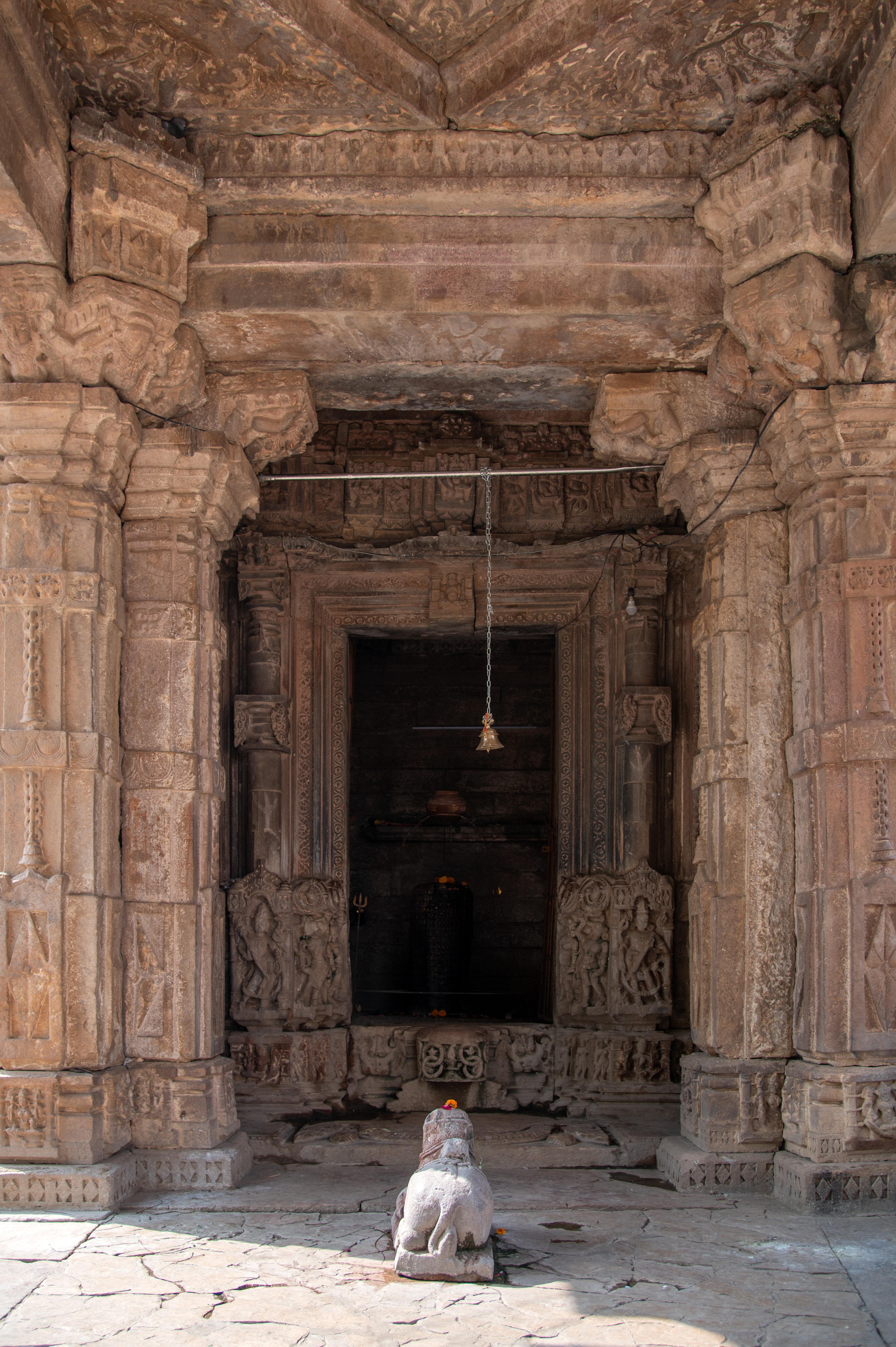 The mandapa (pillared hall) of the Hazareshwar Temple is a small square open hall which stands on a low base, supported by four pillars positioned at its corners. These pillars feature square bases adorned with depictions of deities. The shaft of the pillars is intricately carved with male deities, musicians, dancers and surasundaris (celestial damsels). Transitioning into an octagonal shape, then into sixteen facets and circular, the shaft culminates with an abacus supporting bharavahaka (load bearers) brackets, which in turn uphold the lintel. The mandapa's ceiling, square in shape, is exquisitely carved. There is an idol of Nandi housed at the centre of the mandapa.