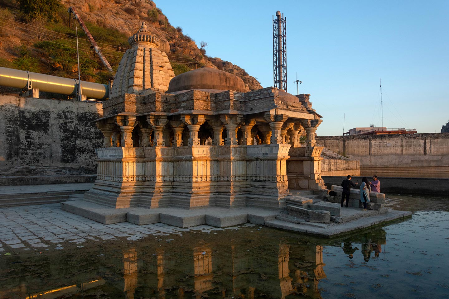 The Gokarneshwara, or Bisaldeo Temple, is situated in a courtyard near the Bisalpur dam on the banks of the Banas river. The temple’s architectural layout includes a garbhagriha (sanctum sanctorum), an antarala (vestibule or antechamber), a mahamandapa (pillared hall) with lateral transepts and an ardhamandapa (partially enclosed hall). It is a nirandhara prasada, meaning it lacks the pradakshina patha (circumambulatory path). The sanctum is pancharatha (consisting of five projections on each side) on plan, and its walls are plain in design.