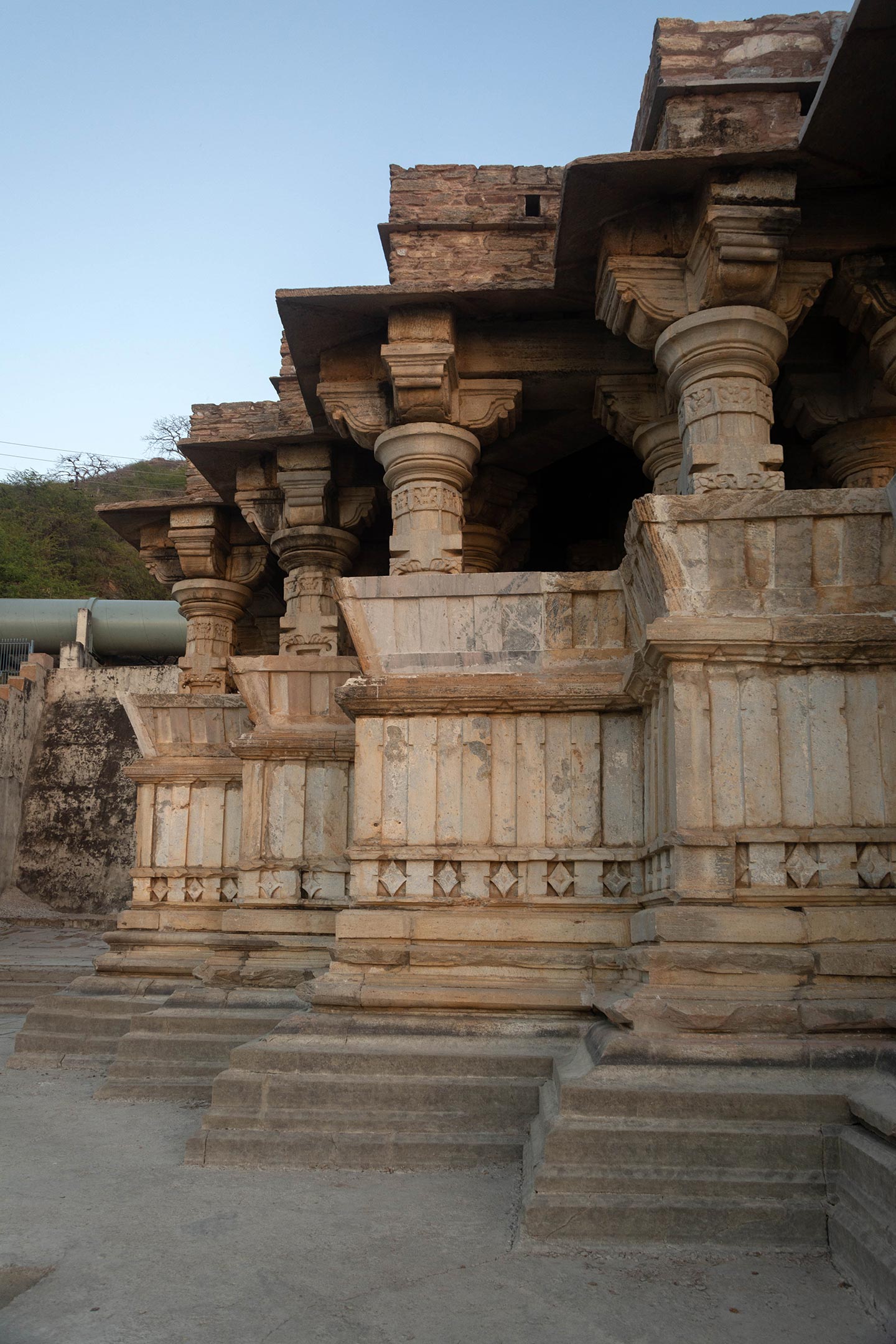 The mahamandapa (pillared hall) features lateral protrusions on either side, providing asanapatta and kakshasana (elevated sitting area or seat backs), above which are five dwarf pillars. It is connected to the ardhamandapa (partially closed hall), which also has dwarf pillars. The mouldings of the mahamandapa and ardhamandapa differ from those of the sanctum.