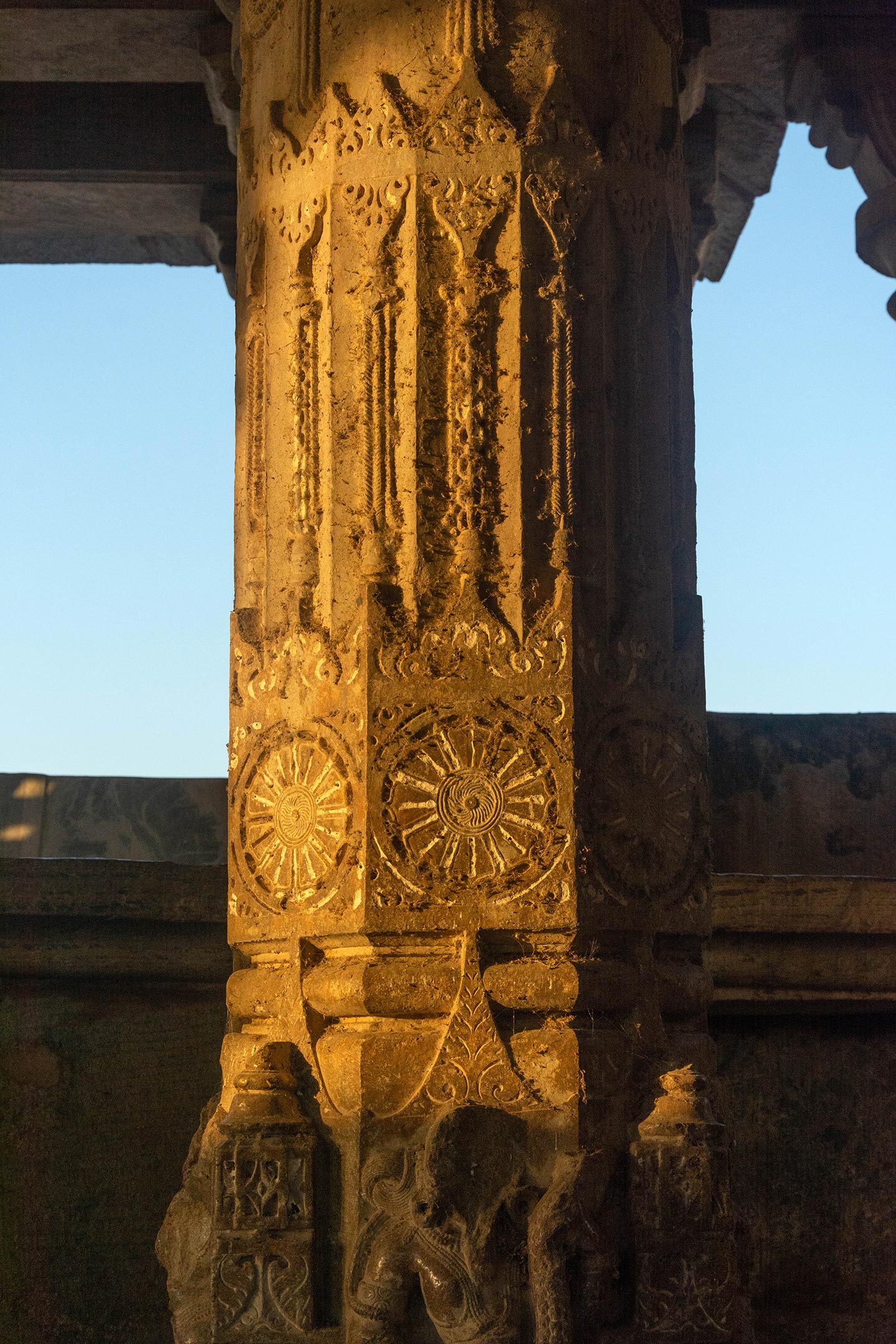 The pillar in the mahamandapa (pillared hall) features an octagonal design in the middle portion, adorned with intricate carvings of foliage, hanging bells, and spoked wheels.