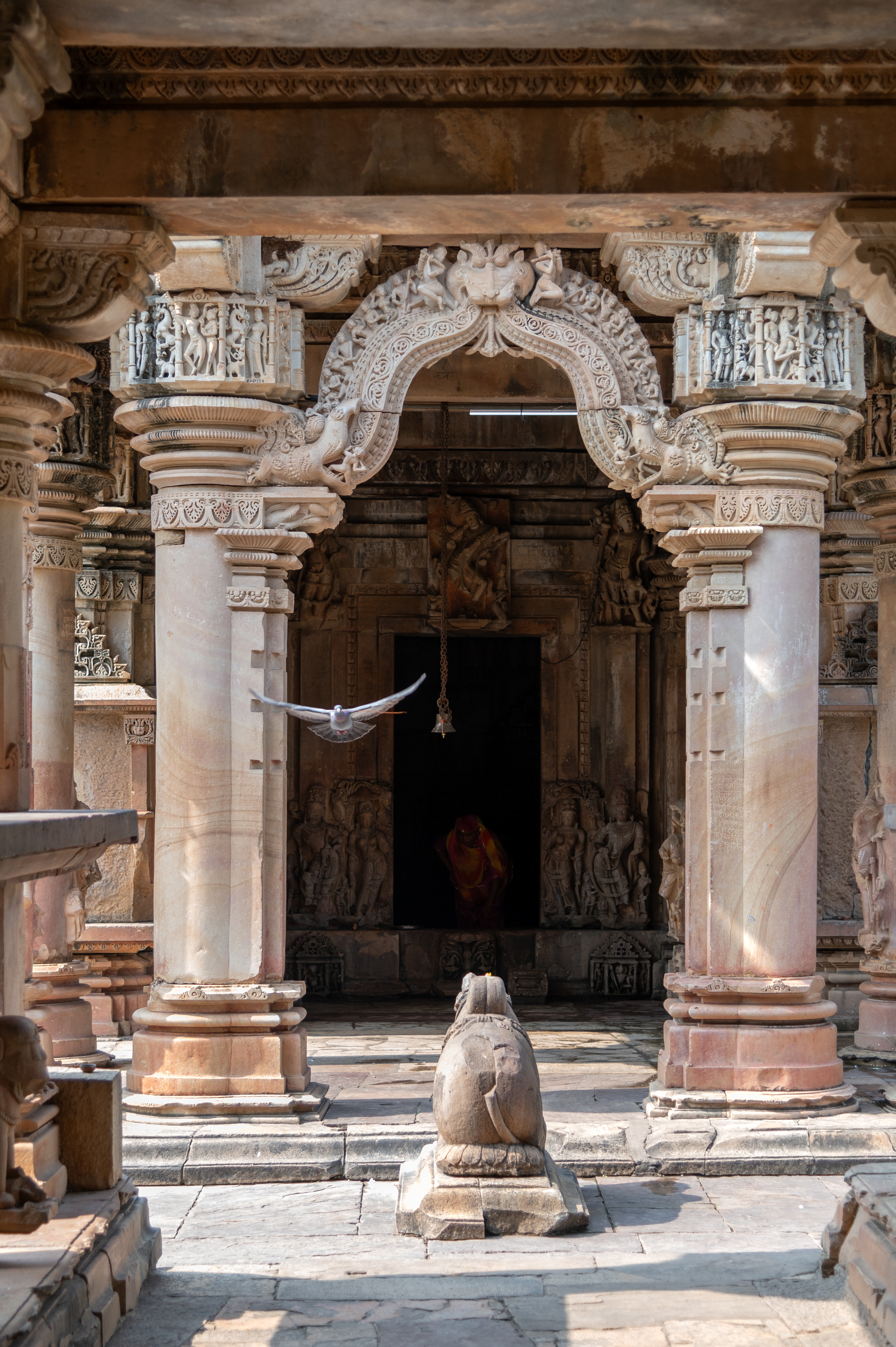 Image 7: View of the mukhamandapa (front porch) of the Ghateshwar Temple with torana (ornamental archway) entrance, with Nandi in front.