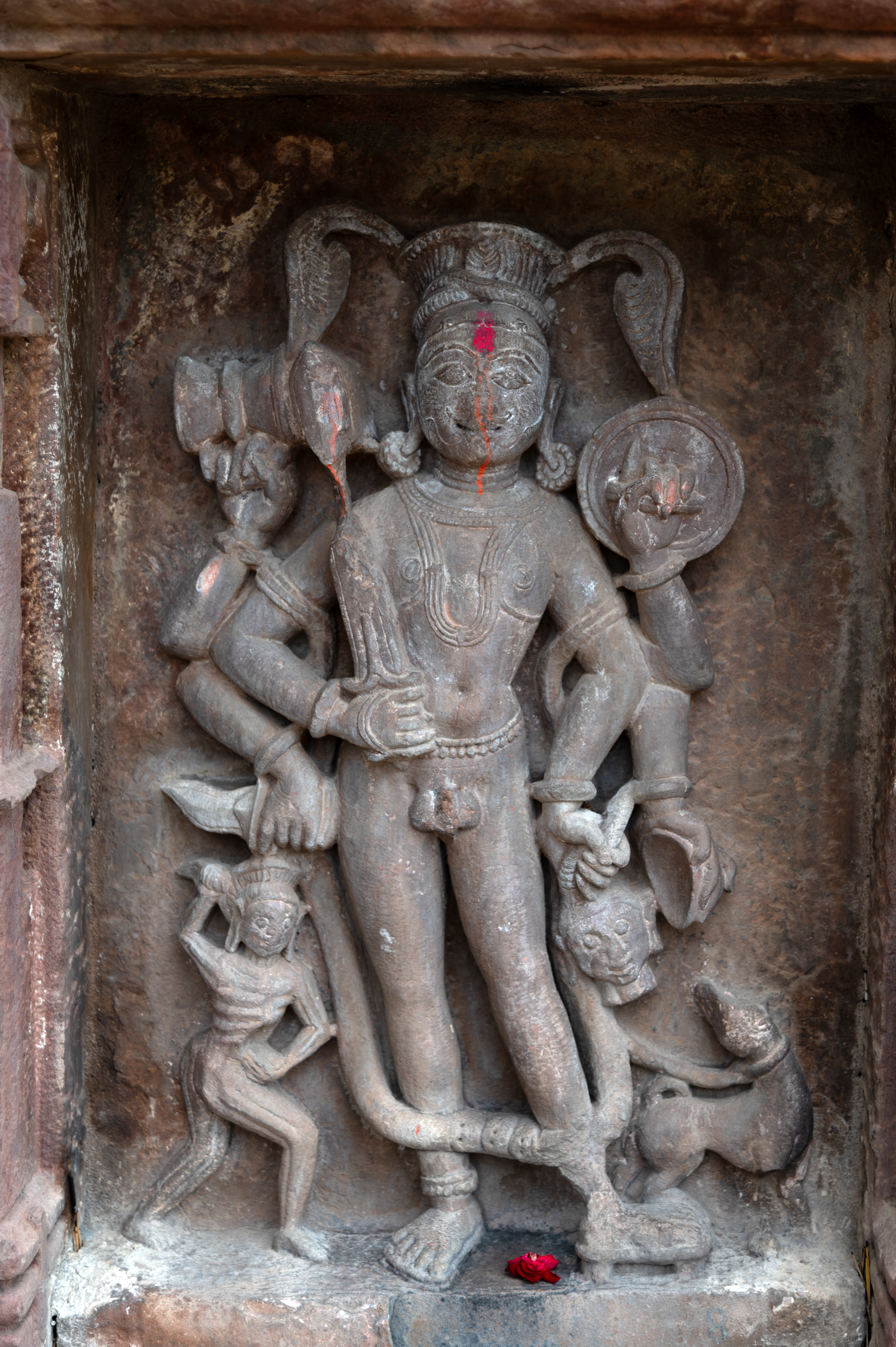 The right-side wall of the entrance gateway to the Mahanaleshwar complex features a sculpture of a six-handed Bhairava in a devakoshtha (niche). The attributes that Bhairava holds include a kapala (human skull), a khatvanga (staff with a human skull), a damru (hourglass-shaped drum), a khadga (dagger), a dhal (shield), and a talwar (a type of sword). A dog and a skeletal figure flank the Bhairava sculpture.