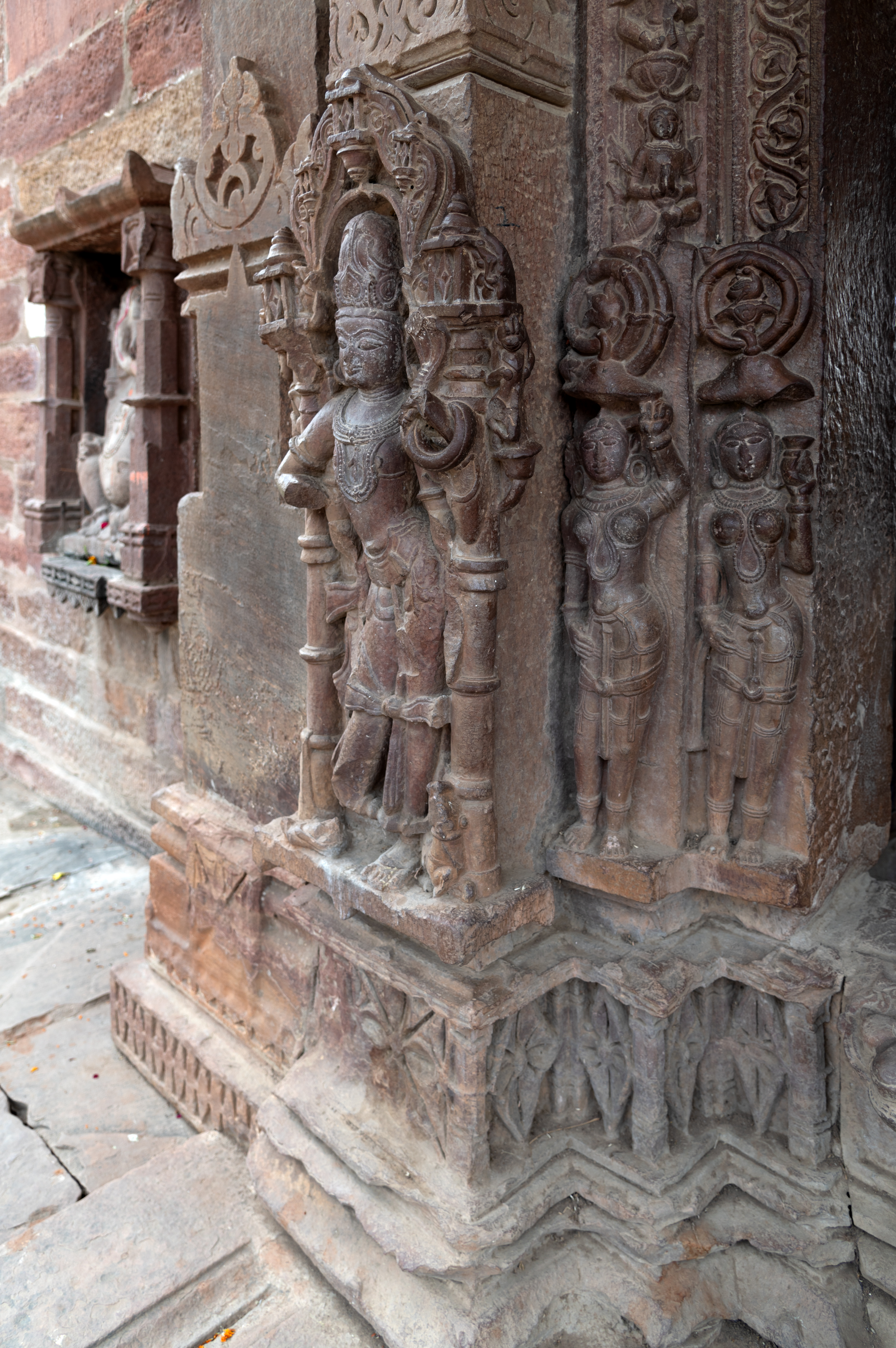 Three sculptures, one attendant and two river goddess figures, adorn the lower portion of the doorframe of the Mahanaleshwar temple complex. Below these sculptures is the ratnapatta (plinth with diamond motif).