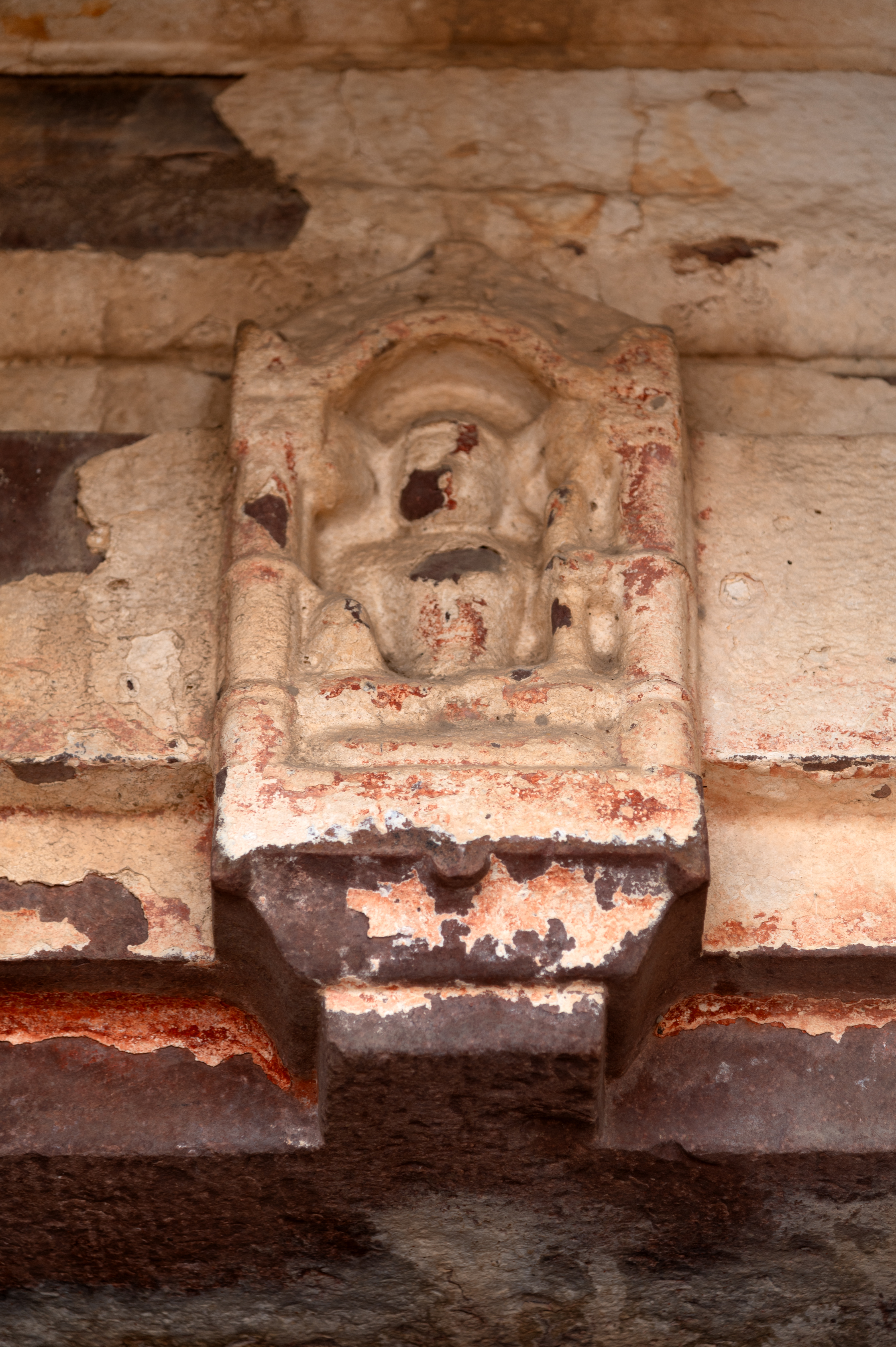 A seated image of Lakulisa is seen here on the latatabimba (lintel) of the shrine along the western boundary of the Mahanaleshwar temple complex. The deity carries a lakut (staff) in his hand. Lakulisa is a form of Shiva that is central to the Pashupata Shaivism tradition.