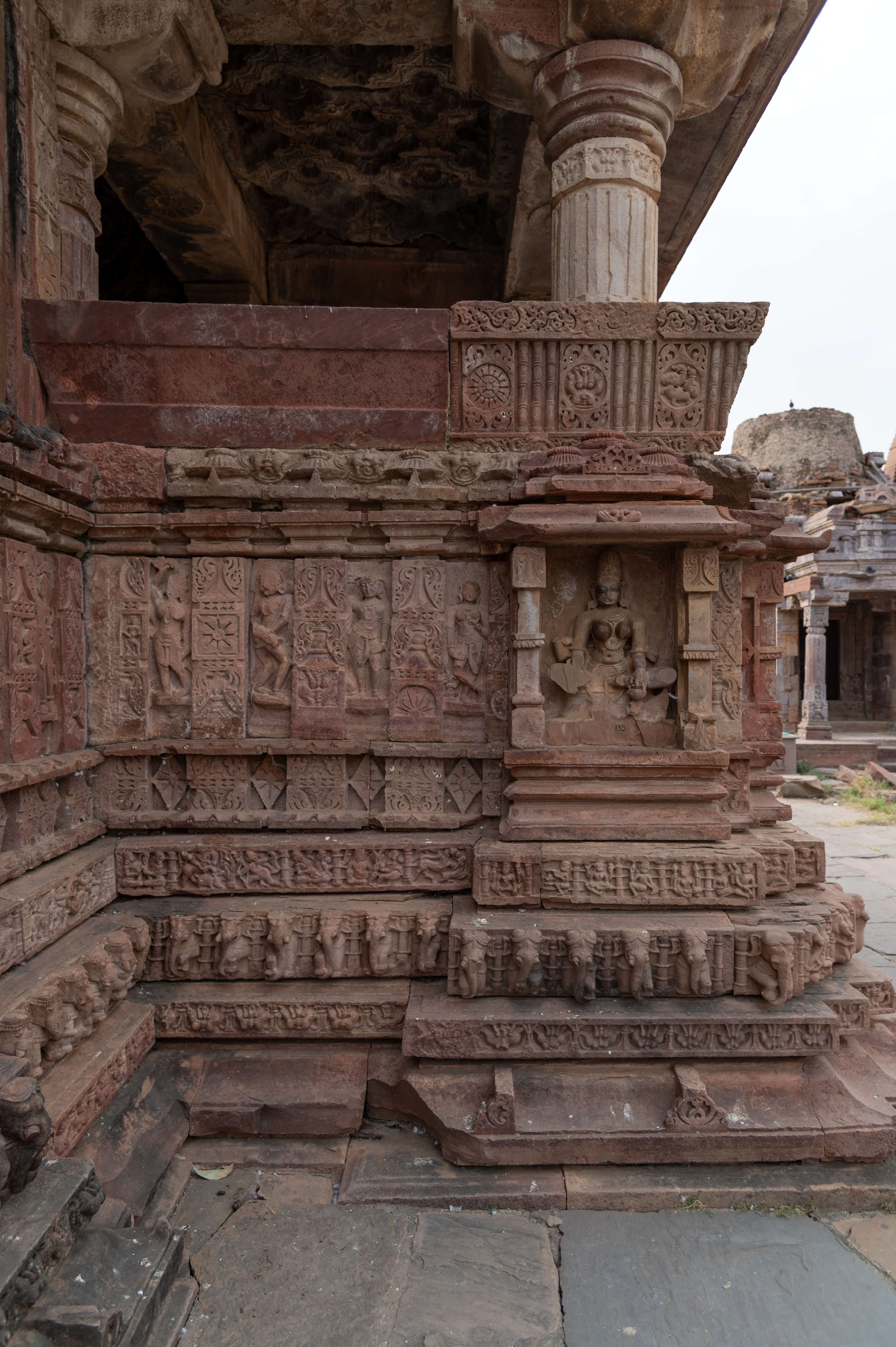 The northern side lateral transept attached to the mandapa (pillared hall) of the Mahanleshwar Temple has devakoshthas (niches) on all sides containing deities. There is probably a broken sculpture of a river goddess in one of the niches, flanked by a row of pilaster motifs and dancing figures. The dwarf wall of the transept has kakshasana (seat backs) containing designs of balustrades separating the sculptural depictions formed in circles.