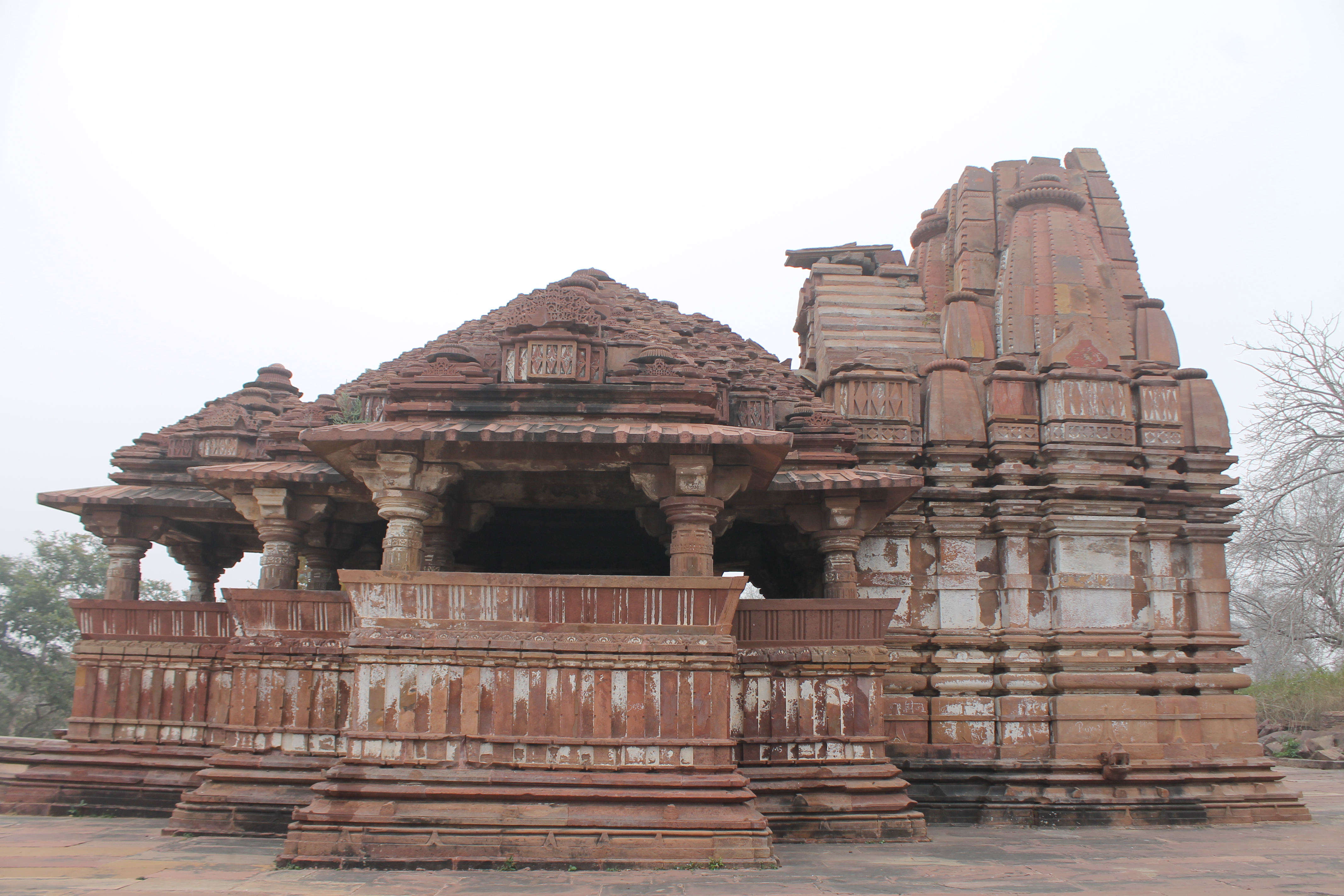 The north-facing elevation of the Suhaveshwar Temple is identical to the south-facing side. The protruding shukanasa, the front of the shikhara (superstructure), is visible here. It is a semi-circular opening. The topmost portion of the main shikhara is missing. The mandapa (pillared hall) shikhara, along the temple's elevation, has a row of large ghantikas (aedicules) that cascade from the center. A gavaksha (dromer window) design tops a square block with diamond motifs at the base of the mandapa shikhara.