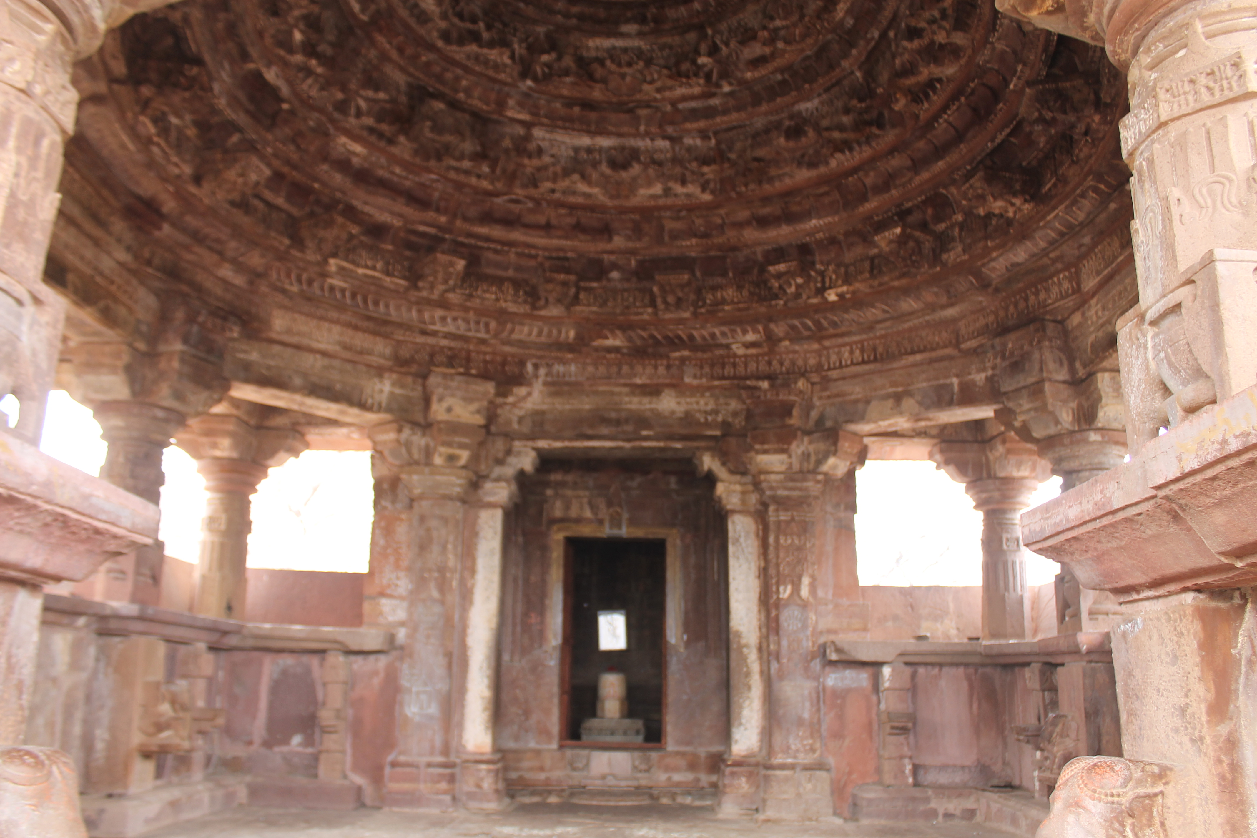 The Suhaveshwar Temple's mandapa (pillared hall) is square in design, with lateral transepts to the north and south sides. The pillars are located along the mandapa's exterior dwarf walls, which support the circular dome ceiling. The mandapa lacks pillars in its center, indicating that it is of the astylar variety.