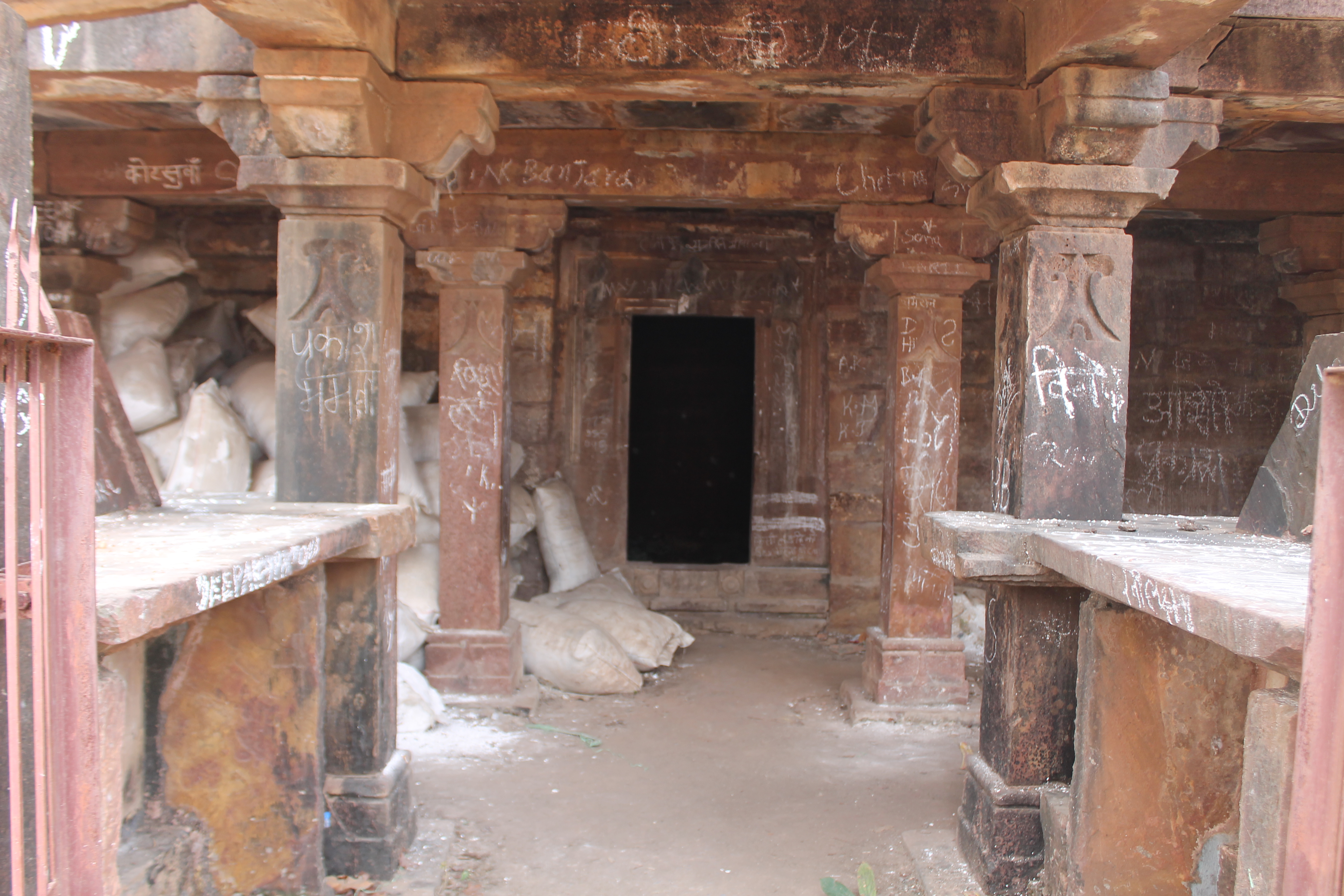 Here are the details of the Suhaveshwar Temple's mukhamandapa (front porch) matha (monastic or residential building). Two walls flank the entrance of the mukhamandapa, which must have had kakshasanas (seat backs) above them. The corners are marked by pillars. An enclosed space, possibly serving as a matha shrine, stands in front of the mukhamandapa. The matha's pillars are plain, consisting of rectangular stone slats with minimal ornamentation.