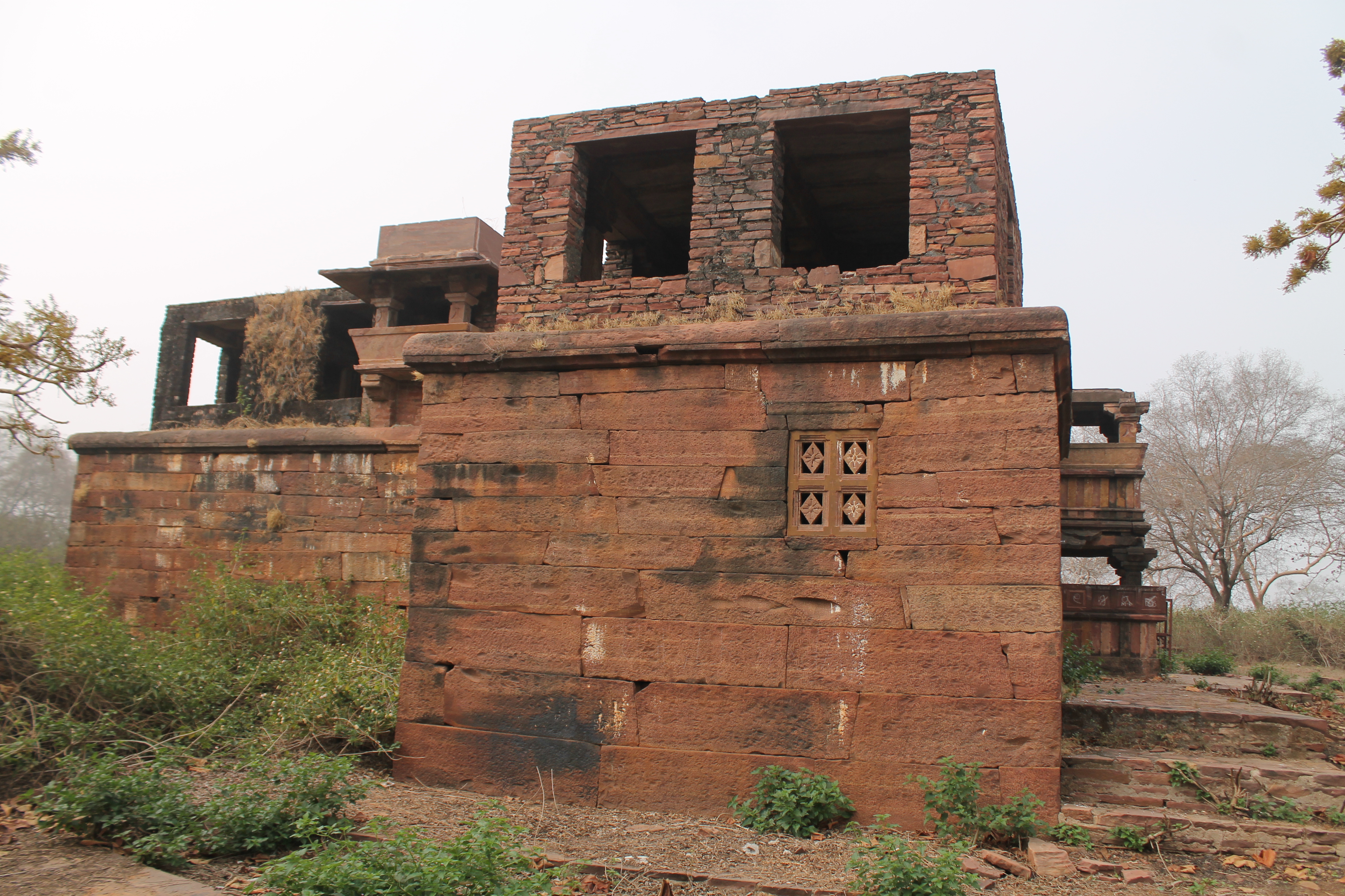 This is a view of the matha (monastic or residential) on the eastern side of the Suhaveshwar temple complex. The matha consists of two long rectangular blocks, with the block on the back side slightly offset from the front. The upper storey of the matha has windows and balconies. The upper storey's side walls have undergone restoration.