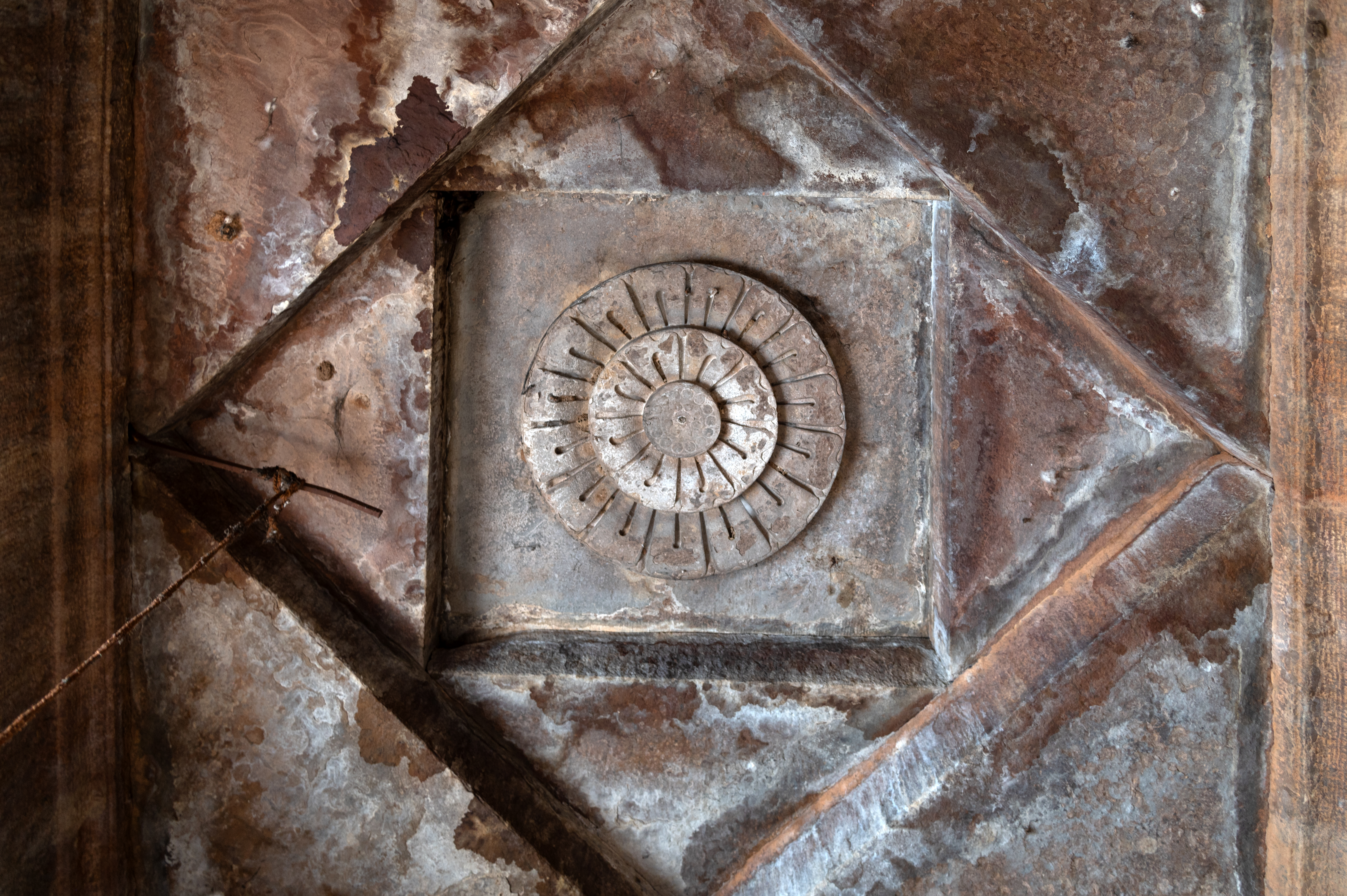 The ceiling of the garbhagriha (sanctum sanctorum) of the Kaner-ki-Putli Temple is square and consists of concentric square designs. It is adorned with a fully bloomed flower in the centre.