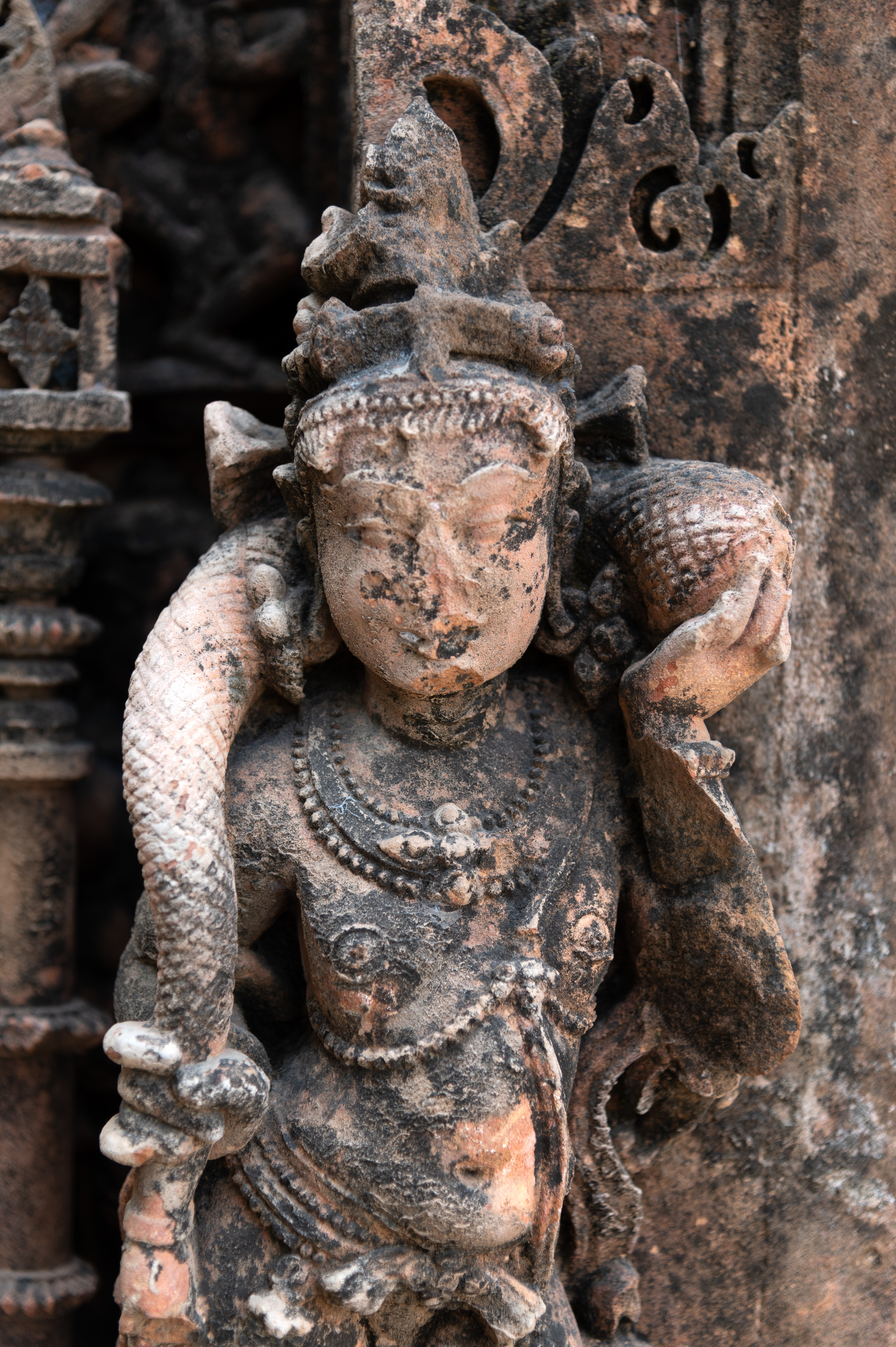 The Vishnu Temple depicts Kubera at the bottommost external shakha (vertical band) of the garbhagriha (sanctum sanctorum) entrance. Kubera stands with two arms, clutching a bag of money, while a pot of nidhi (wealth) rests at the bottom. Kubera is also wearing a crown and jewellery.