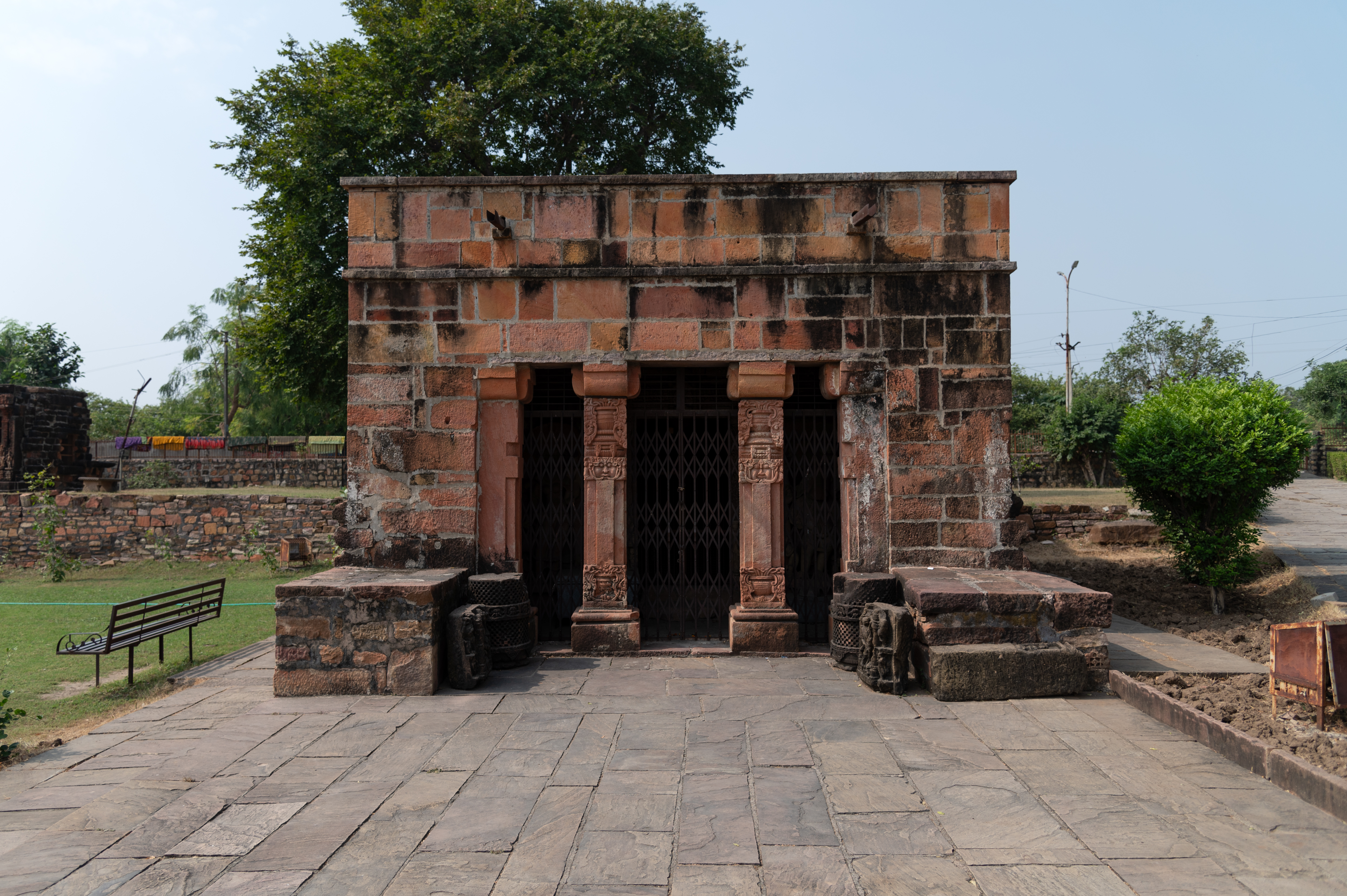 The exterior walls of the Kalika Devi Temple's garbhagriha (sanctum sanctorum) are plain and devoid of decoration or sculptures. The temple features carved pillars at the entrance of the antarala (vestibule or antechamber), accompanied by a few loose sculptures.