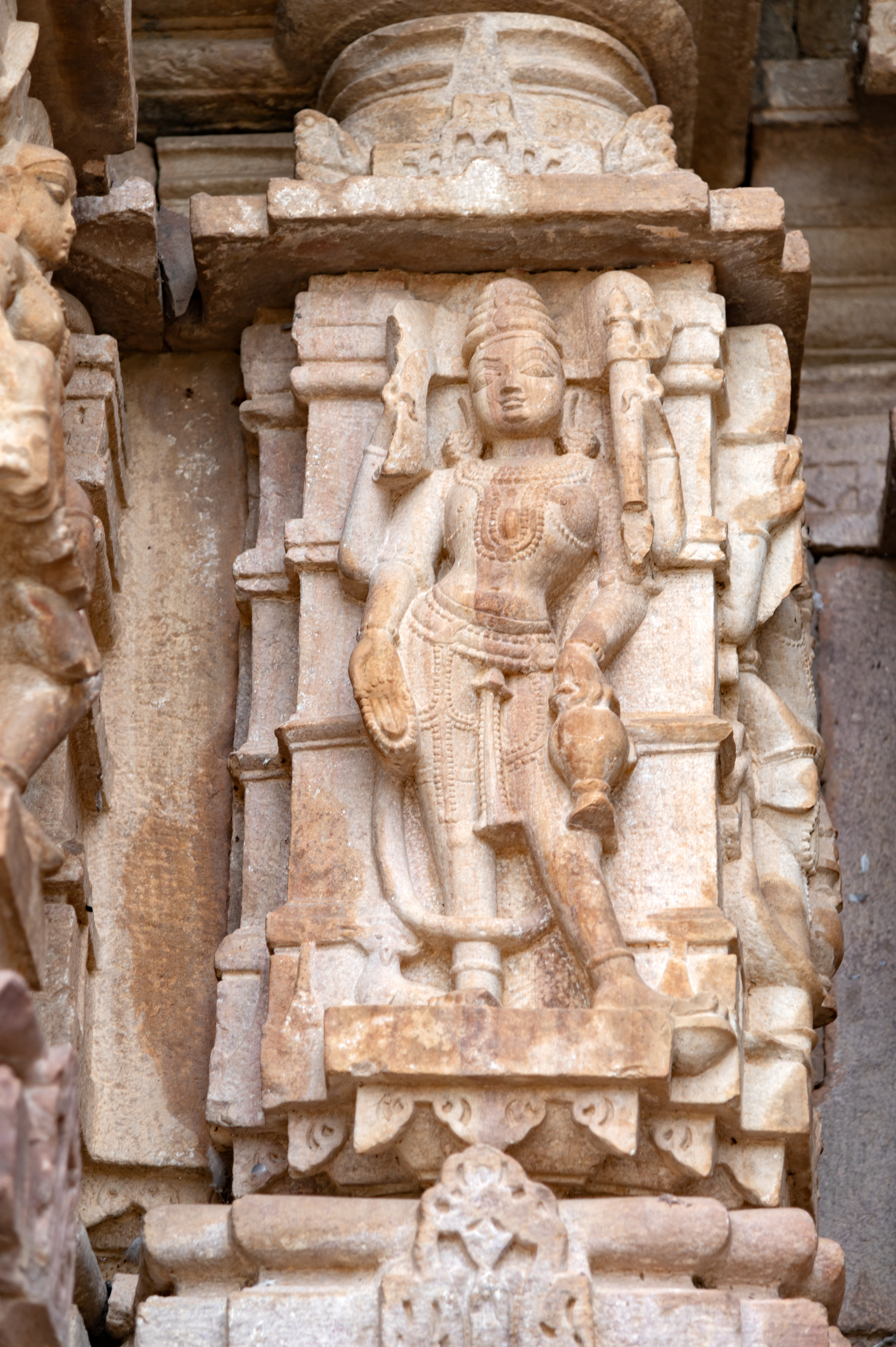 Vayu (one of the deities of the cardinal directions) is depicted with four arms, each holding his respective attributes. Crowned, Vayu is accompanied by his vahana (mount), the antelope, positioned at his feet. In his upper hands, he holds a dhvaja (flag), while his lower left-hand grasps a kamandalu (water pot). His lower right-hand holds a rosary and makes a varada hasta (boon-giving gesture).