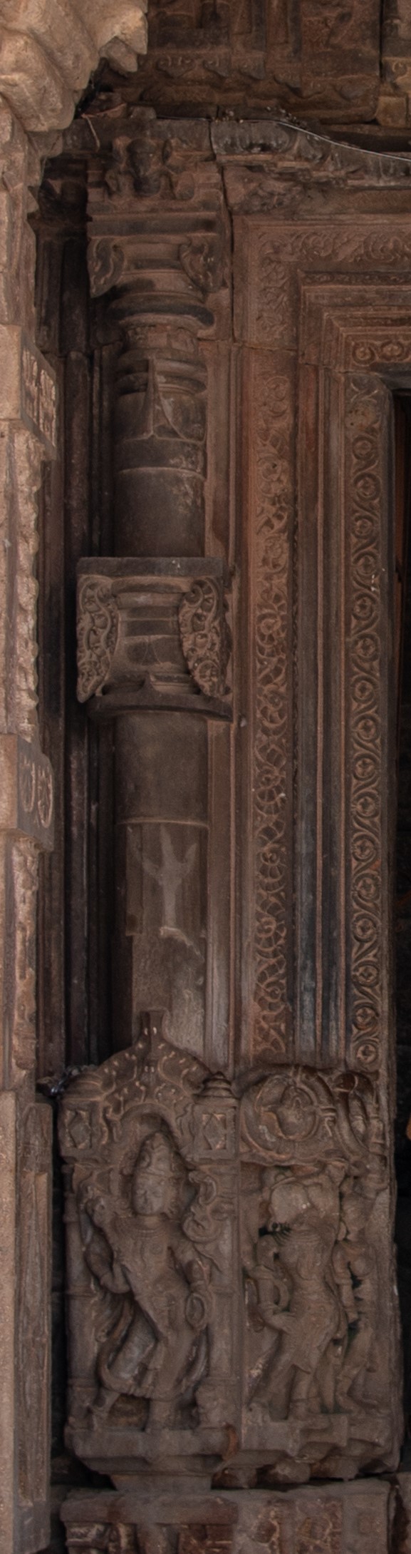 Image 9: The doorframe of the garbhagriha (sanctum sanctorum) has two floral shakhas (vertical bands or branches), a central dominant stambha shakha (pillar-shaped branch) with a purnaghata kalasha (vase and foliage), and an outer shakha adorned with vyalas (composite mythical creatures) arranged in a vertical chain.