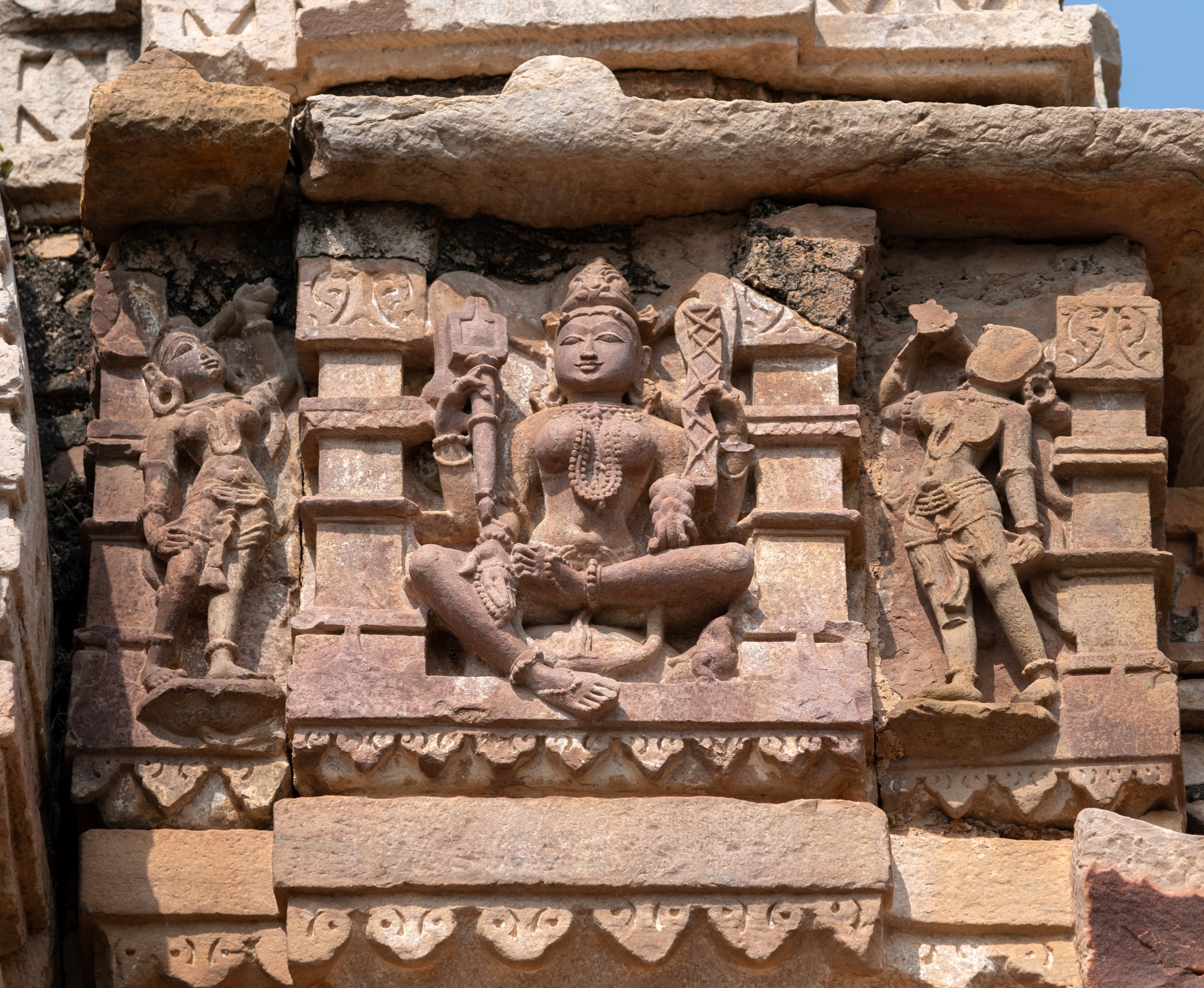 Image 25: Adorning the lateral side of the antarala’s (vestibule) shikhara (superstructure), Brahmani is depicted seated upon a pedestal with four arms, each bearing attributes. In her upper right hand, she holds a shruka (sacrificial ladle), and her upper left hand holds a pustaka (sacred text). Her lower left hand holds a phala (fruit), signifying abundance and nourishment, while her lower right hand is held in the varada hasta gesture, adorned with an akshamala (rosary).